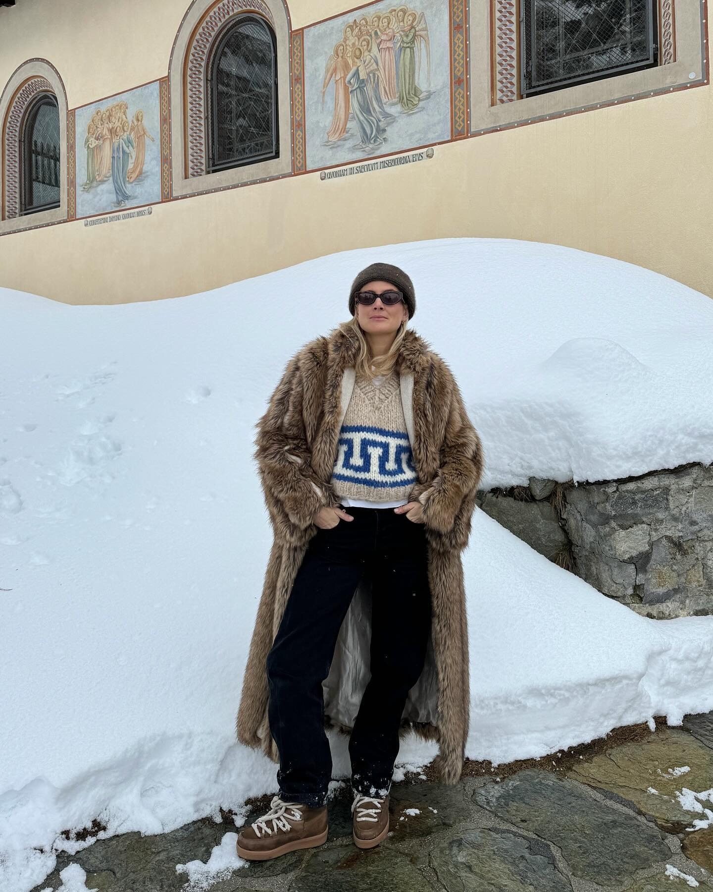 Image of influencer @lucywilliams02 standing outside in the snow wearing a printed jumper with a fur coat and snow boots.