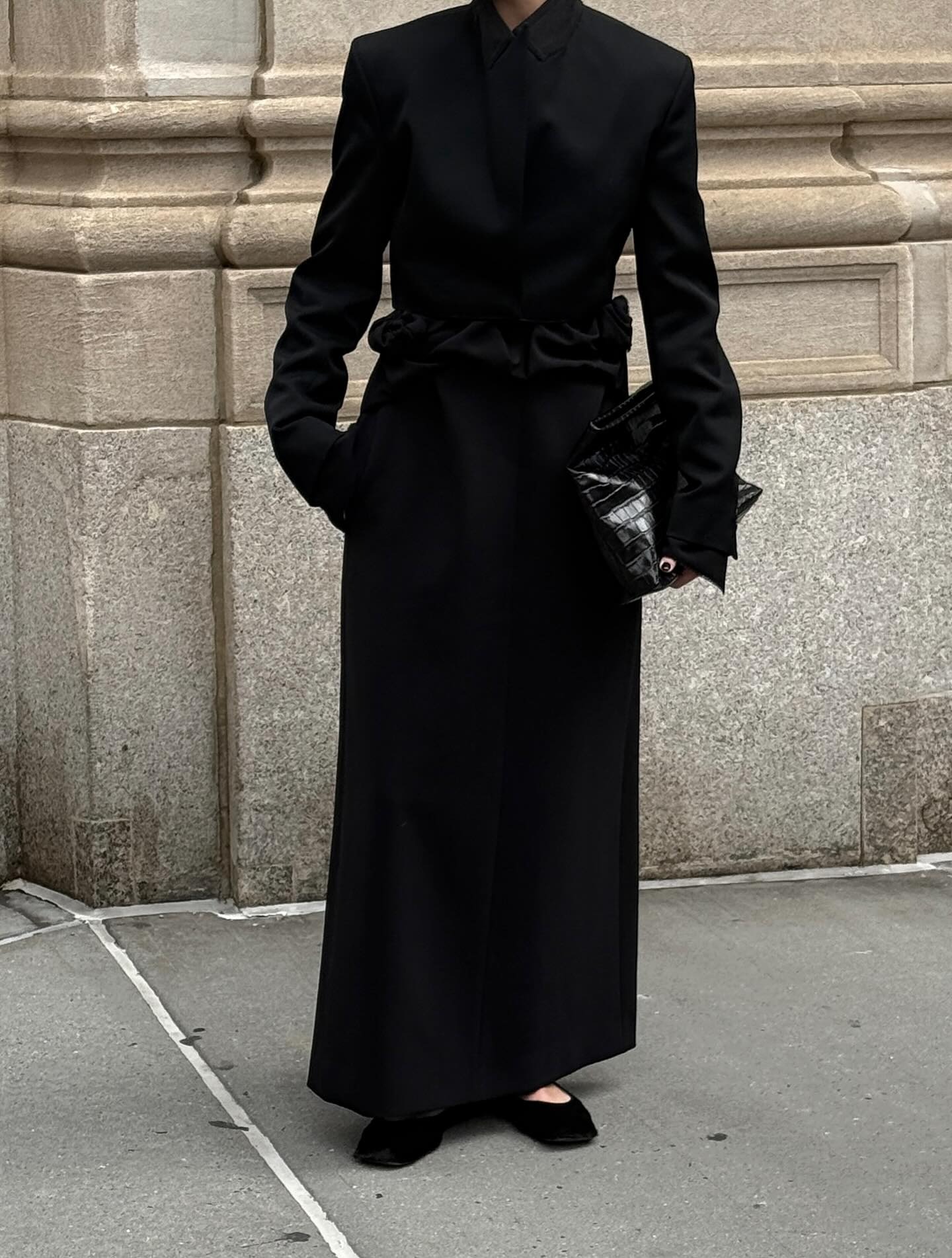 @christietyler wears a long black coat and calf-hair flats.