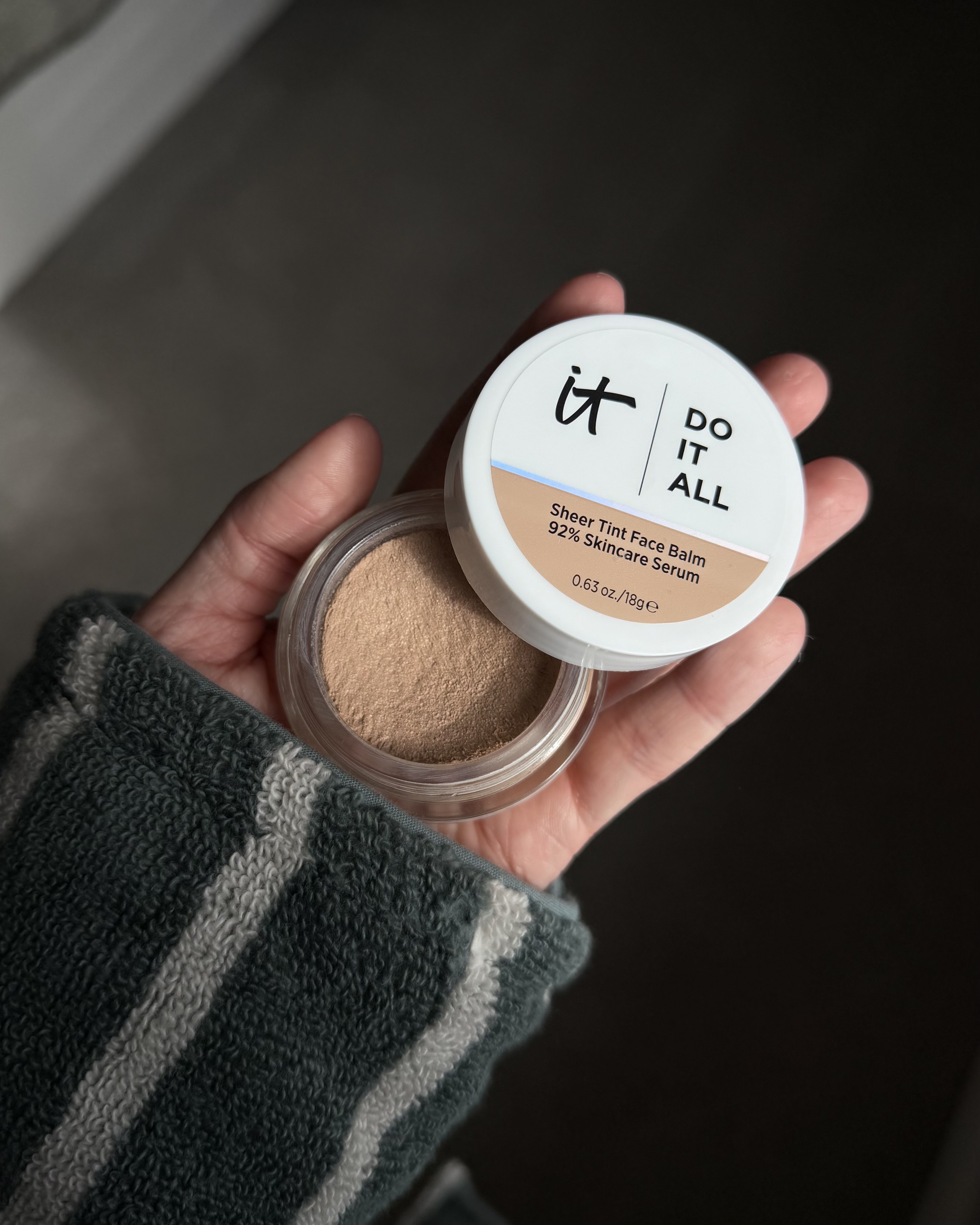 An image of Who What Wear associate beauty editor Alyssa Brascia holding the It Cosmetics Do It All Sheer Tint Face Balm.