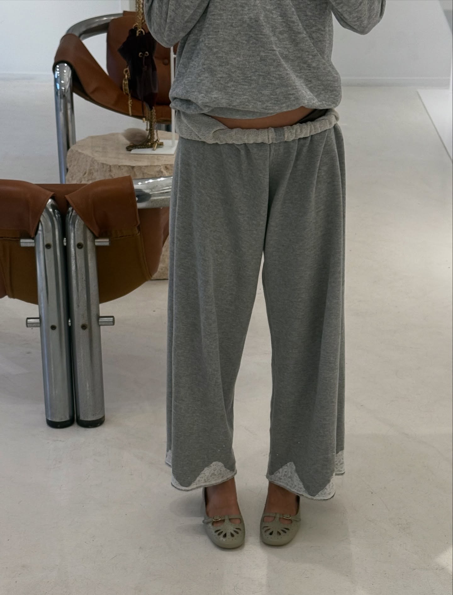 Photo of Iris Law wearing gray sweatpants with green Mary Jane shoes.