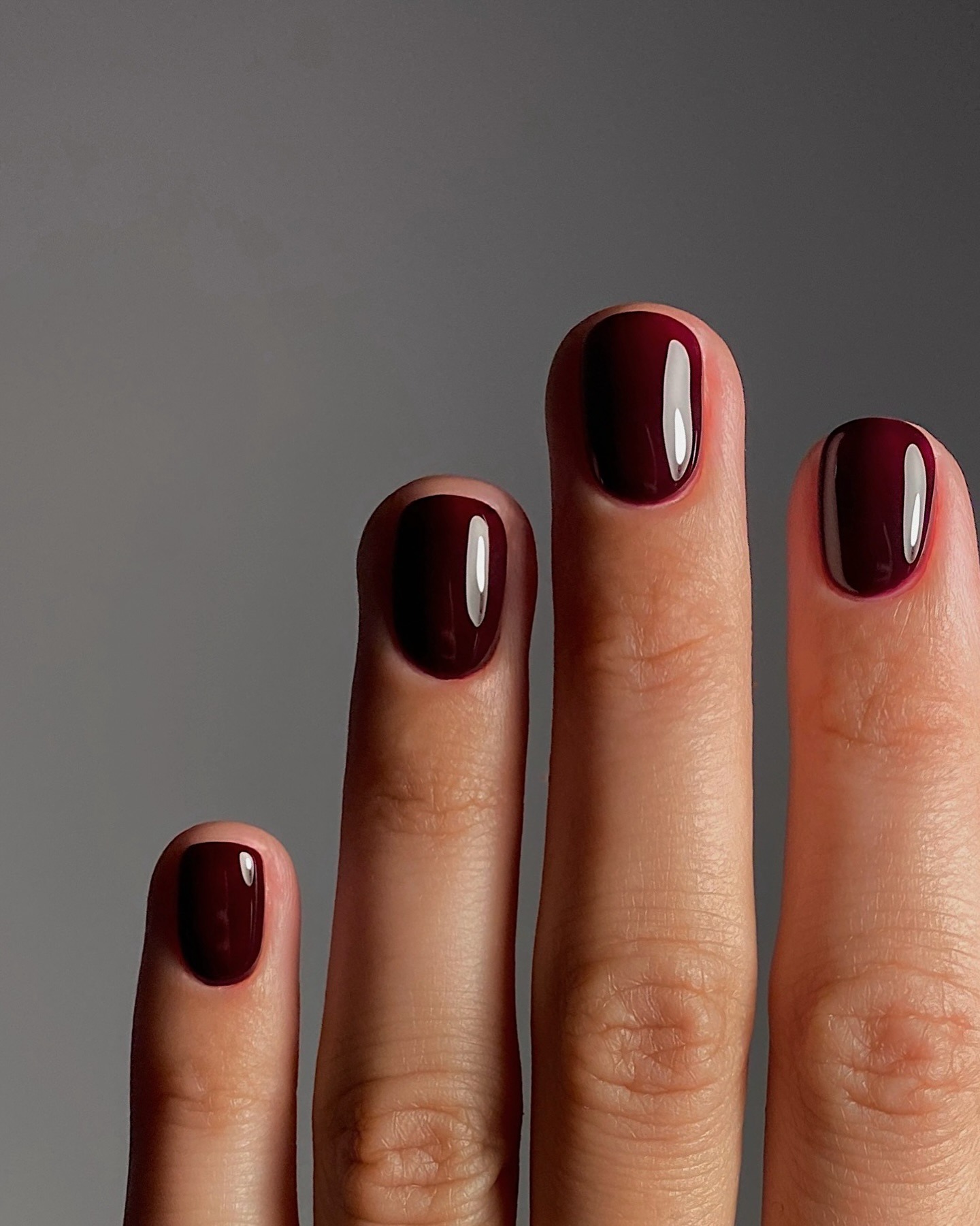 A close-up picture of a short, maroon manicure
