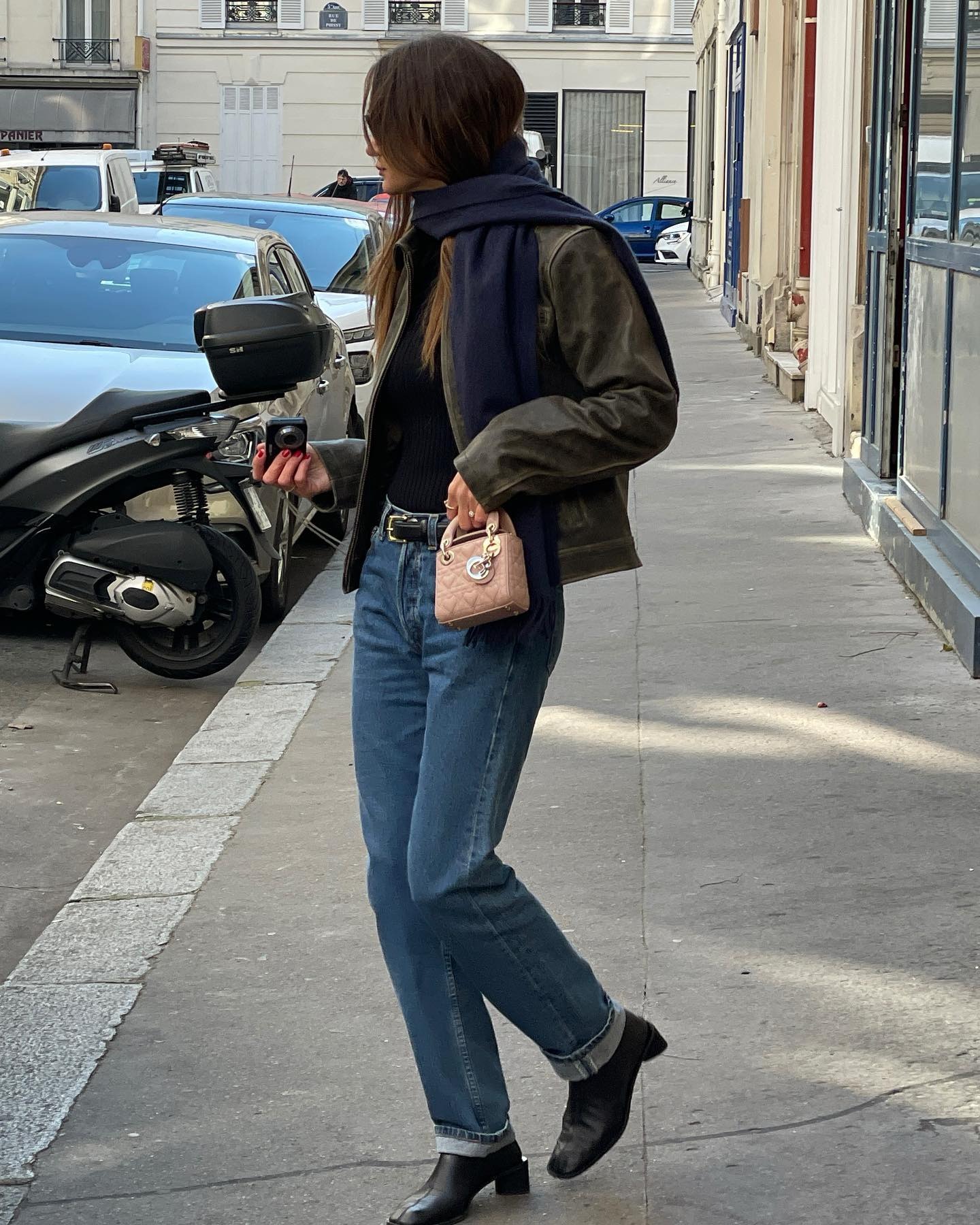 Anne wears cuffed jeans, black ankle boots, dior pink bag, navy scarf, and a leather jacket.