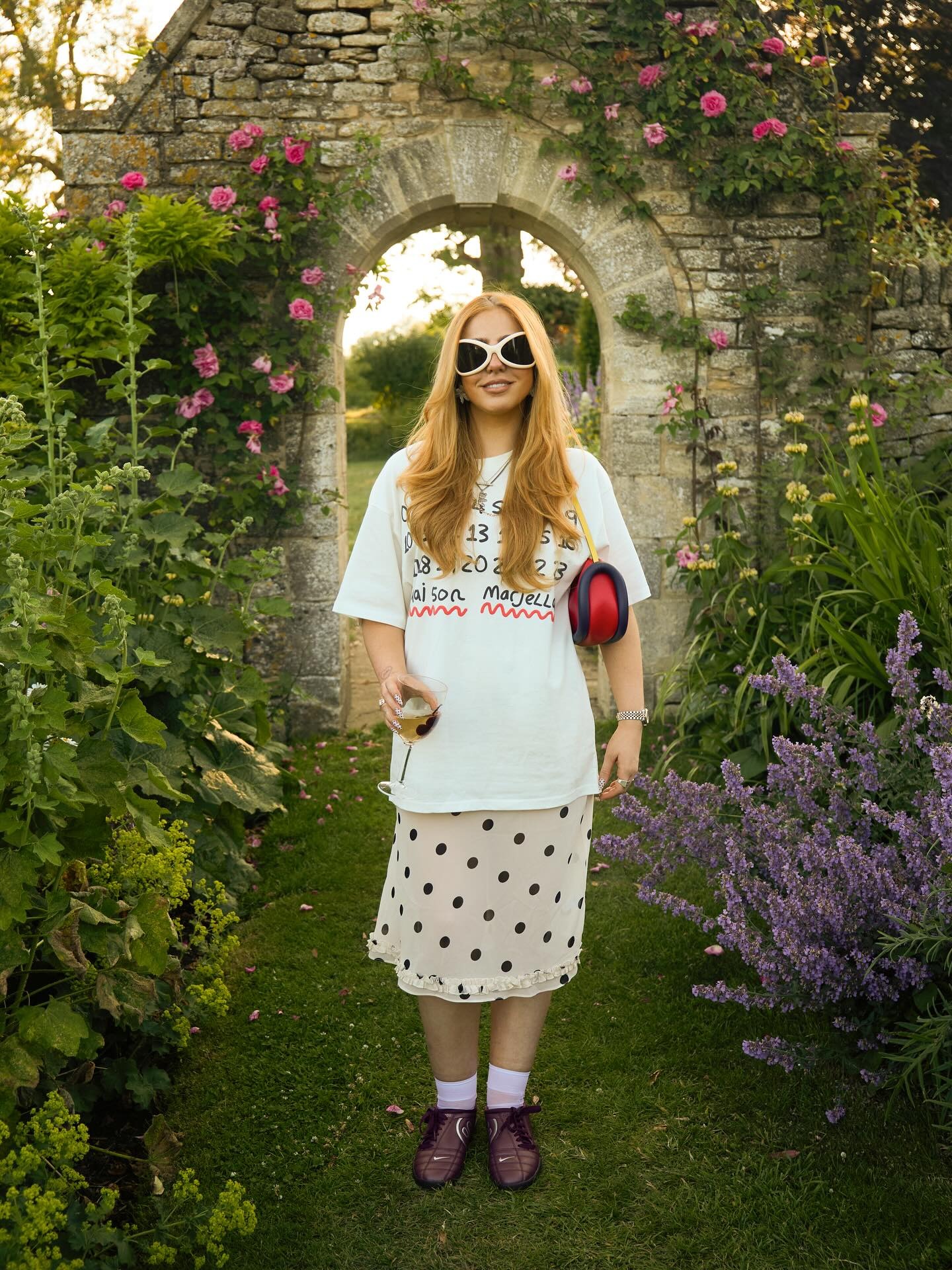 Influencer wears Nike T90 trainers with a polkadot skirt and an oversized tee.