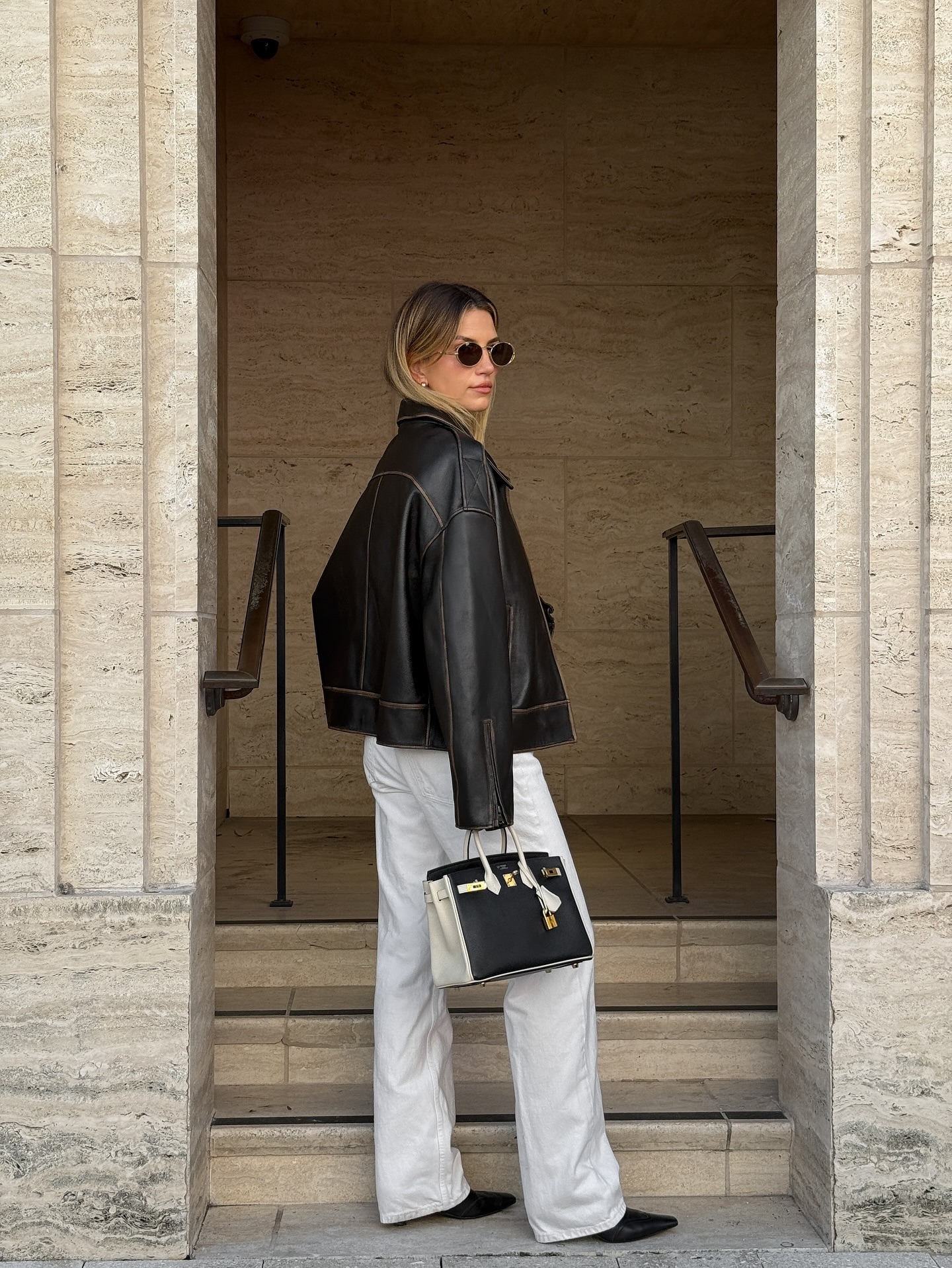 Influencer wearing white jeans with black shoes.