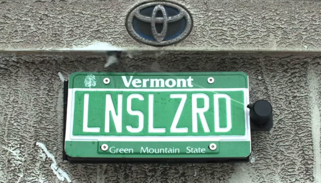 This backup camera cleaner hides behind your license plate