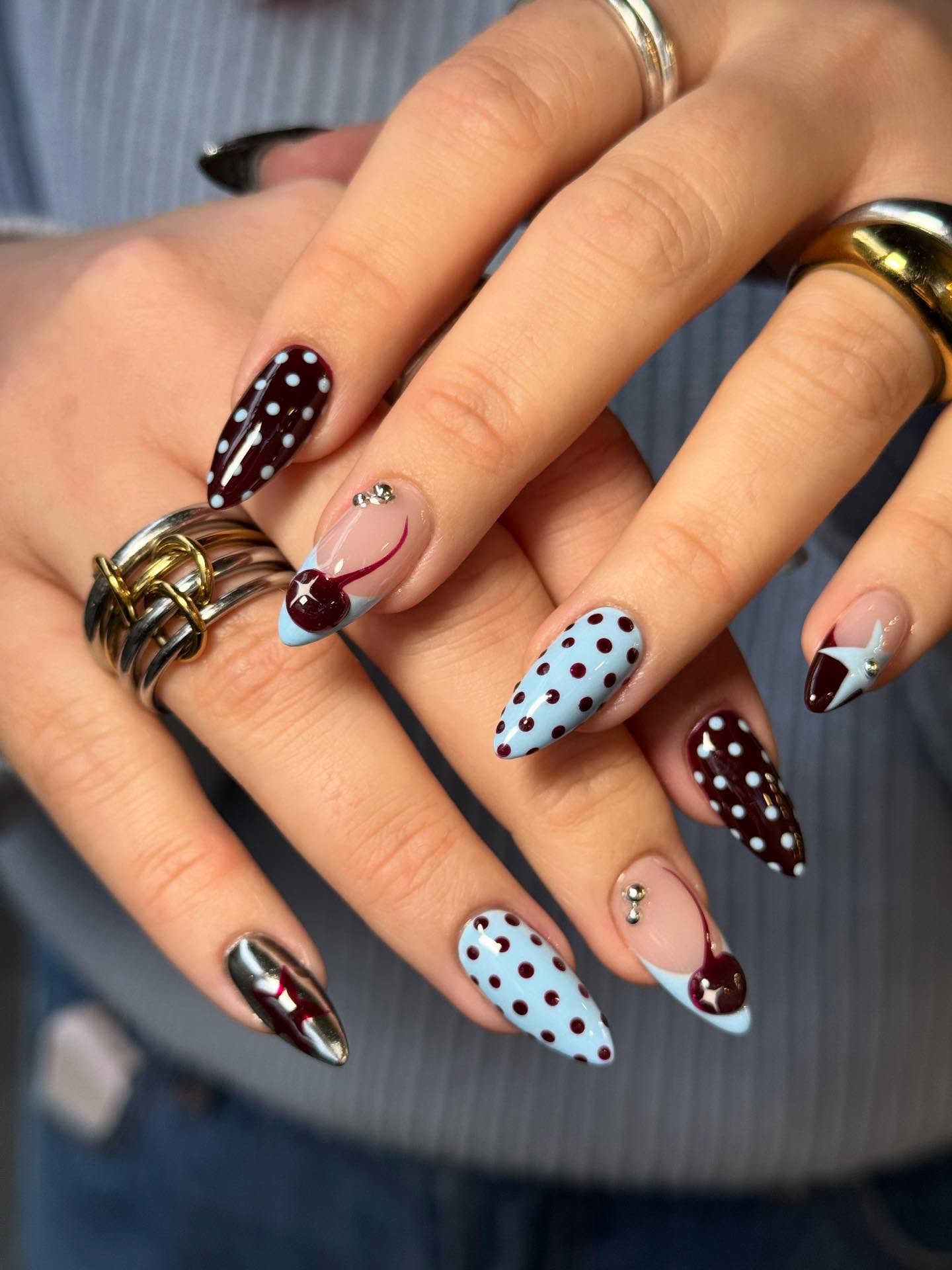 Black cherry purple and baby blue manicure with cherries, stars, and polka dots.