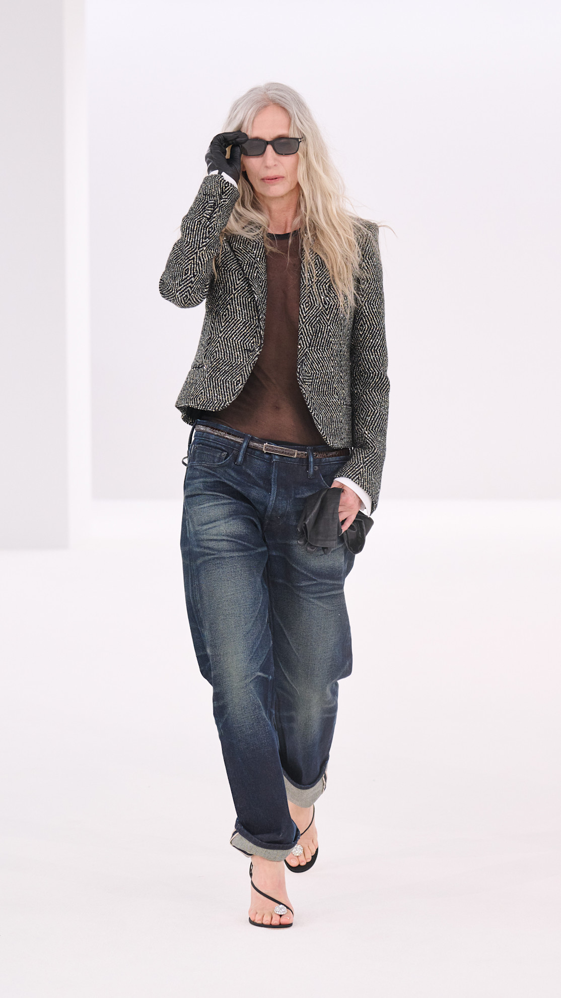 a Tom Ford model wearing a wool jacket, sheer shirt, and denim jeans