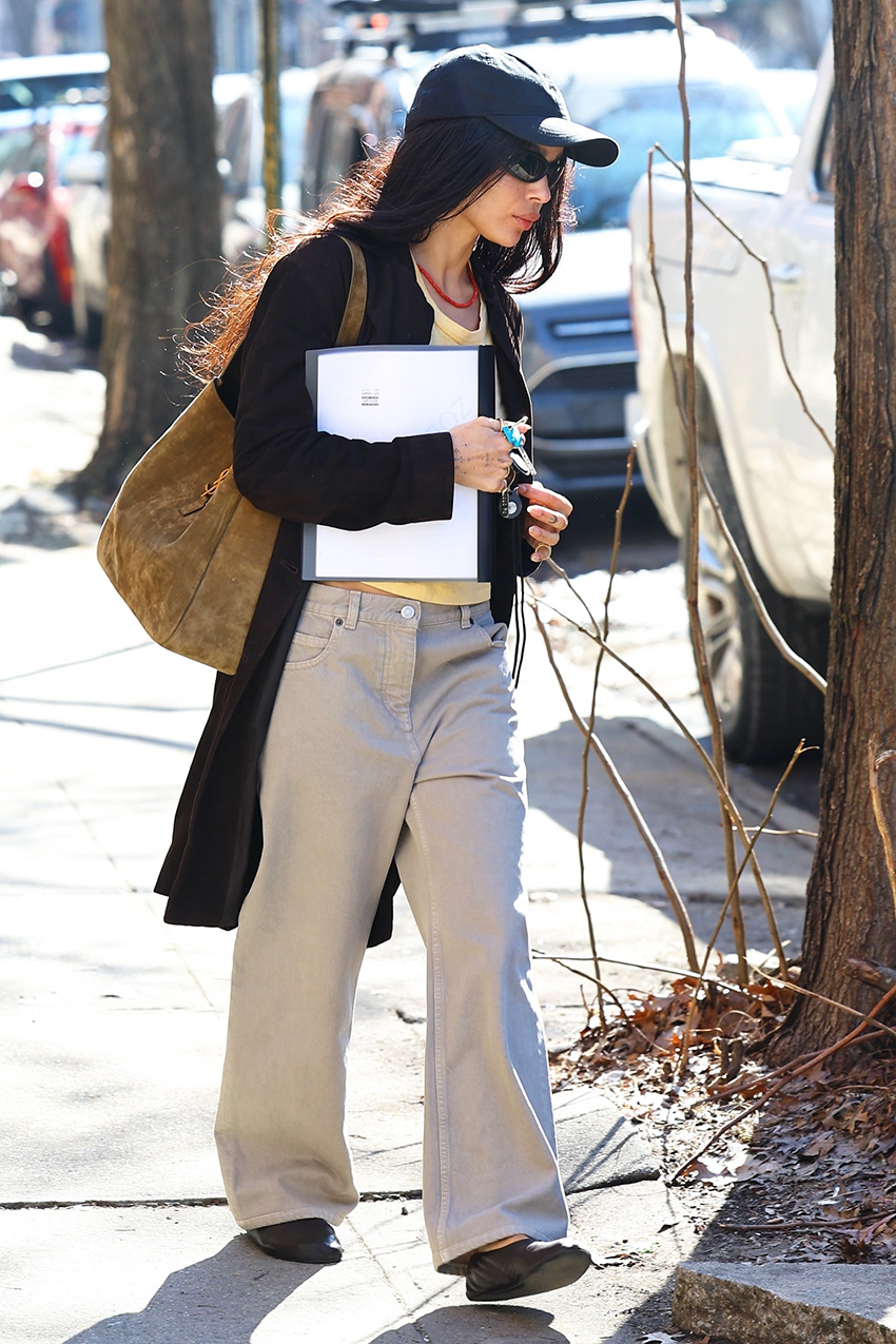 Zo&amp;euml; Kravitz wearing a black cardigan, baseball cap, and hat with khaki jeans in NYC.