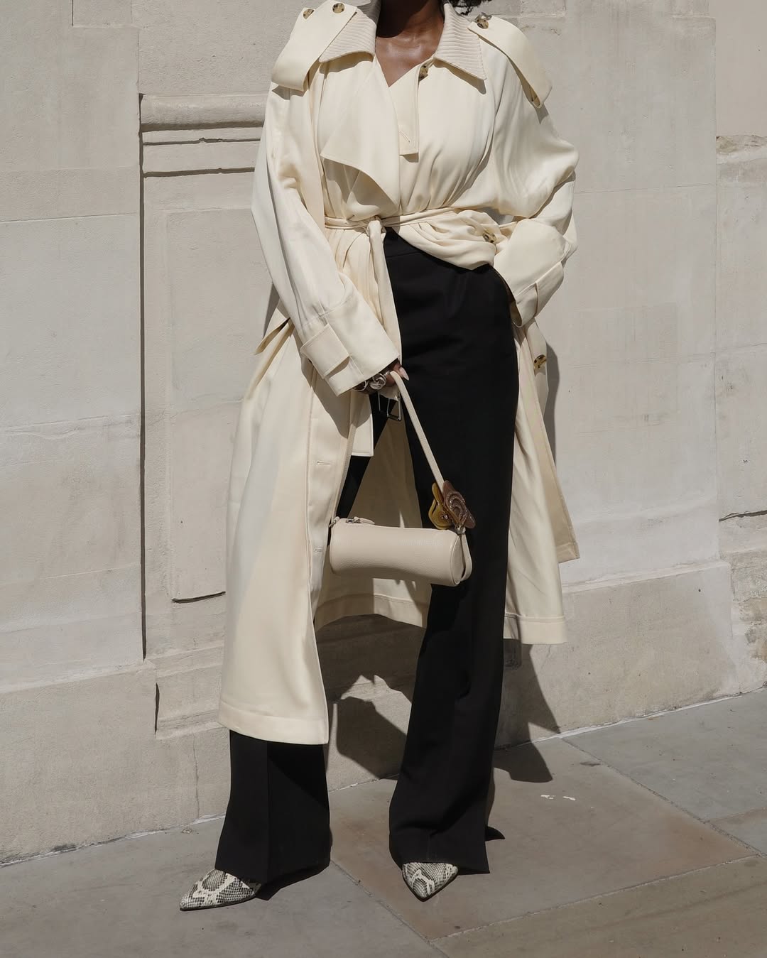 Danielle in a butter trench and black trousers