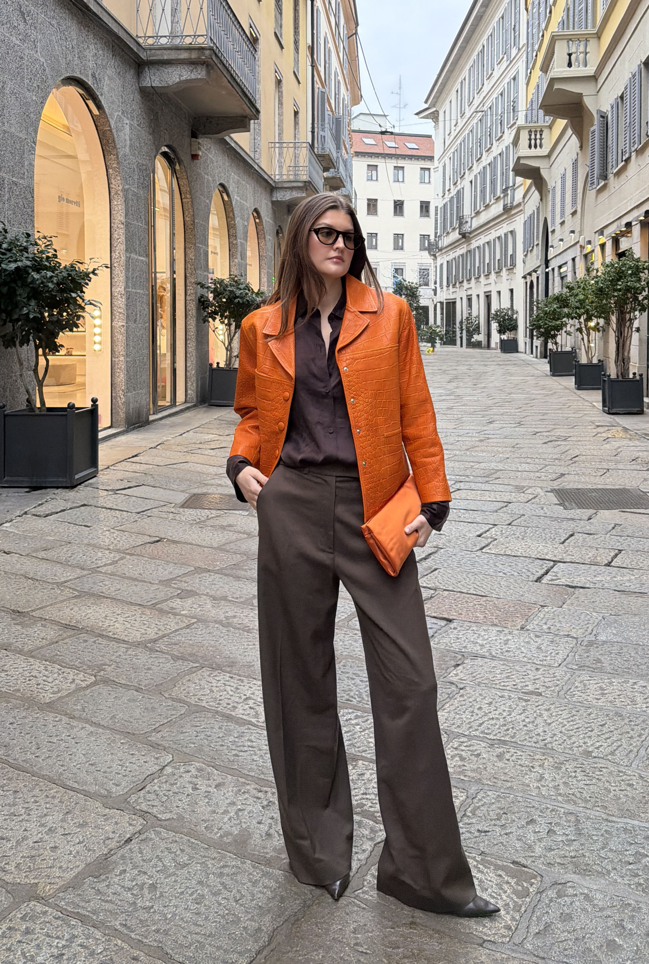 Woman in orange coat and brown outfit