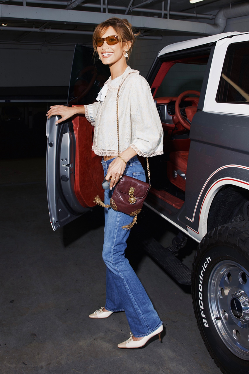 Bella Hadid wearing a pretty white blouse, bootcut jeans, and cap-toe heels