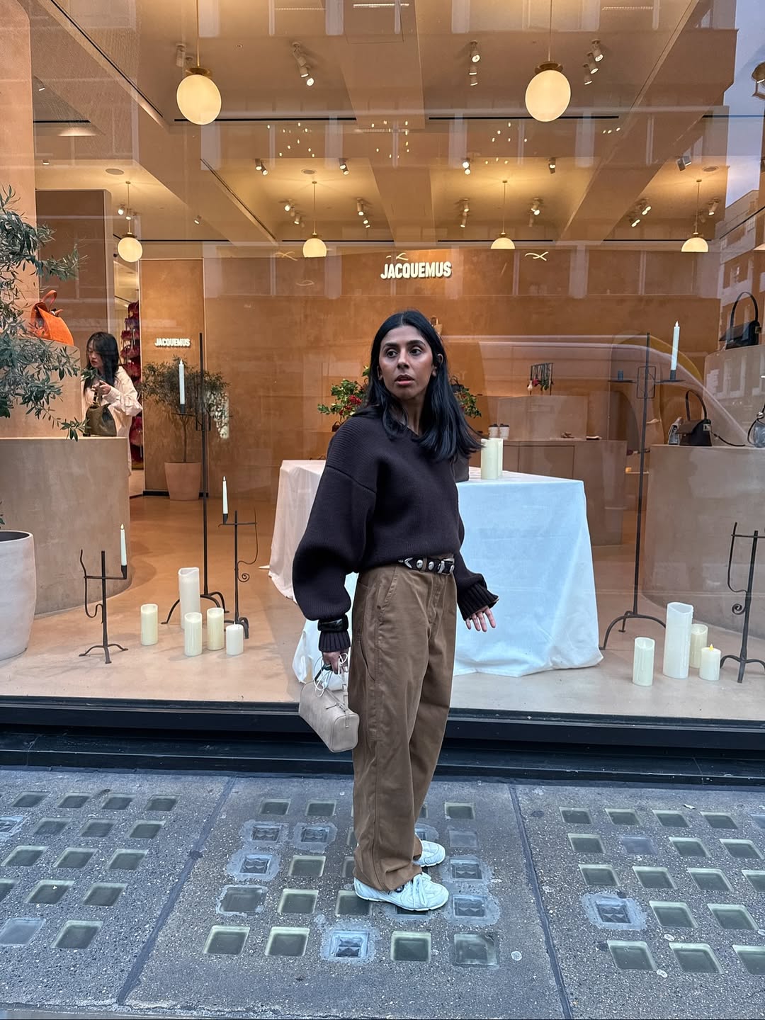 @monikh wears brown jeans, white trainers, brown jumper