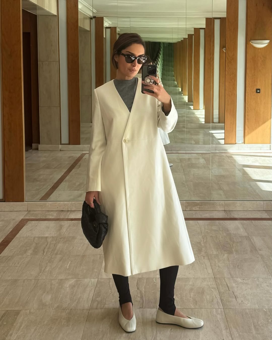 Erin in stirrup leggings and white coat with high-vamp flats