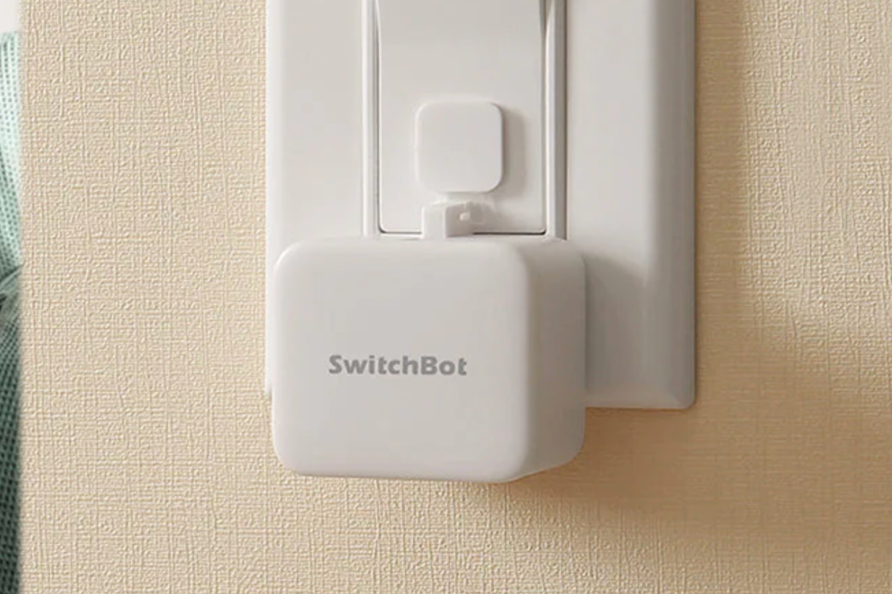 The SwitchBot Bot attached to a light switch.