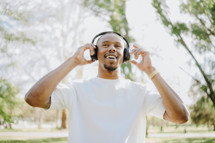 Happy Man Smiling While Listening to Music with Headphones