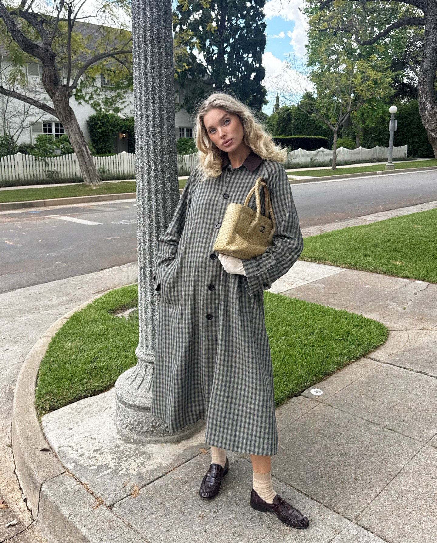 Elsa Hosk wearing a Helsa trench and shorts with a Chanel tote and Comme Si Yves Socks in Khaki