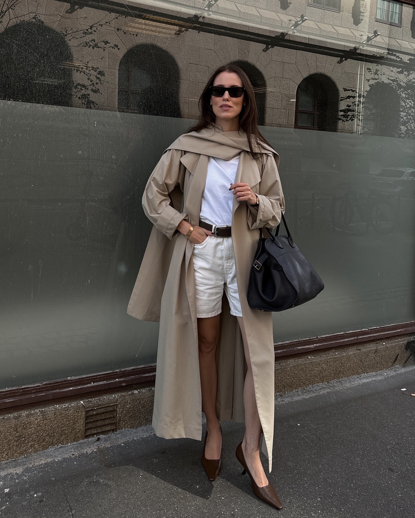 Annabel wears a trench and bermuda shorts.