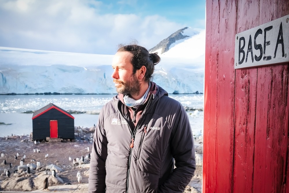 Peter outside a red door saying Base A