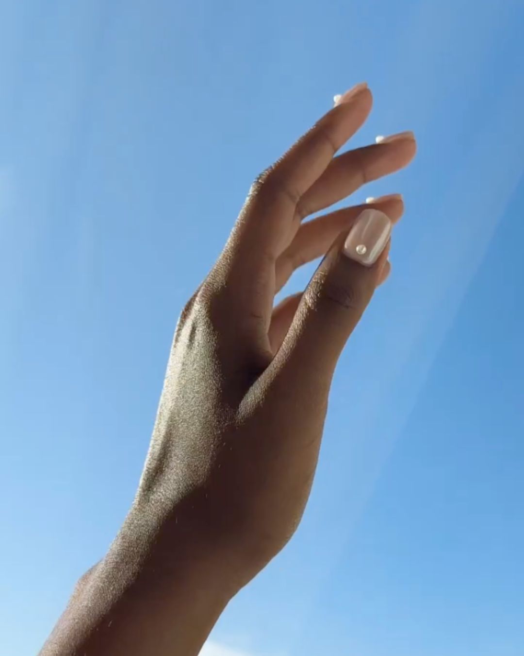 A chrome manicure with 3D pearls.