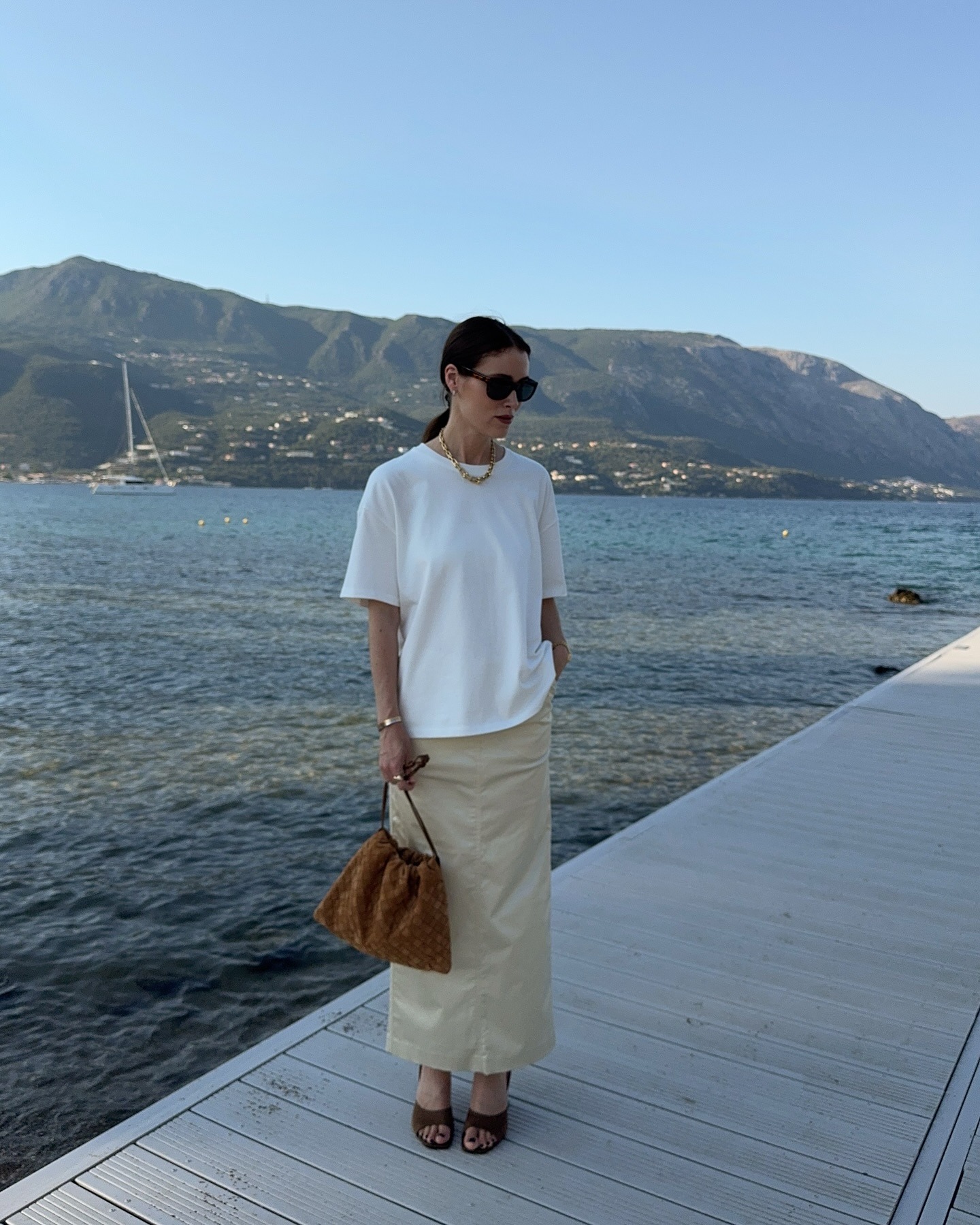 Influencer @annabelrosendahl wears a white t-shirt with a column skirt and a suede handbag.