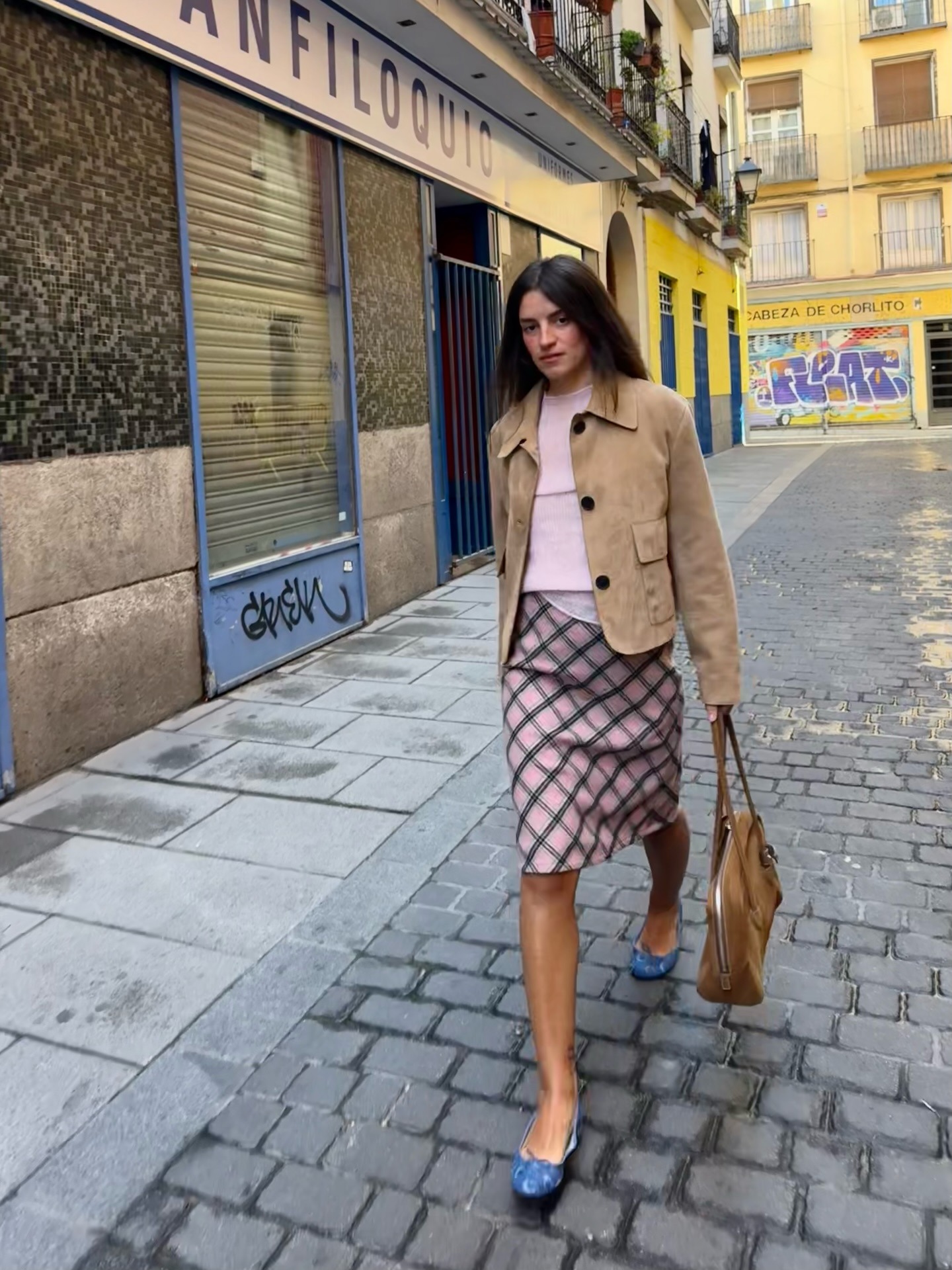 Influencer @monpetitchuchu wears a pink paid skirt with a pink knit and brown suede jacket.