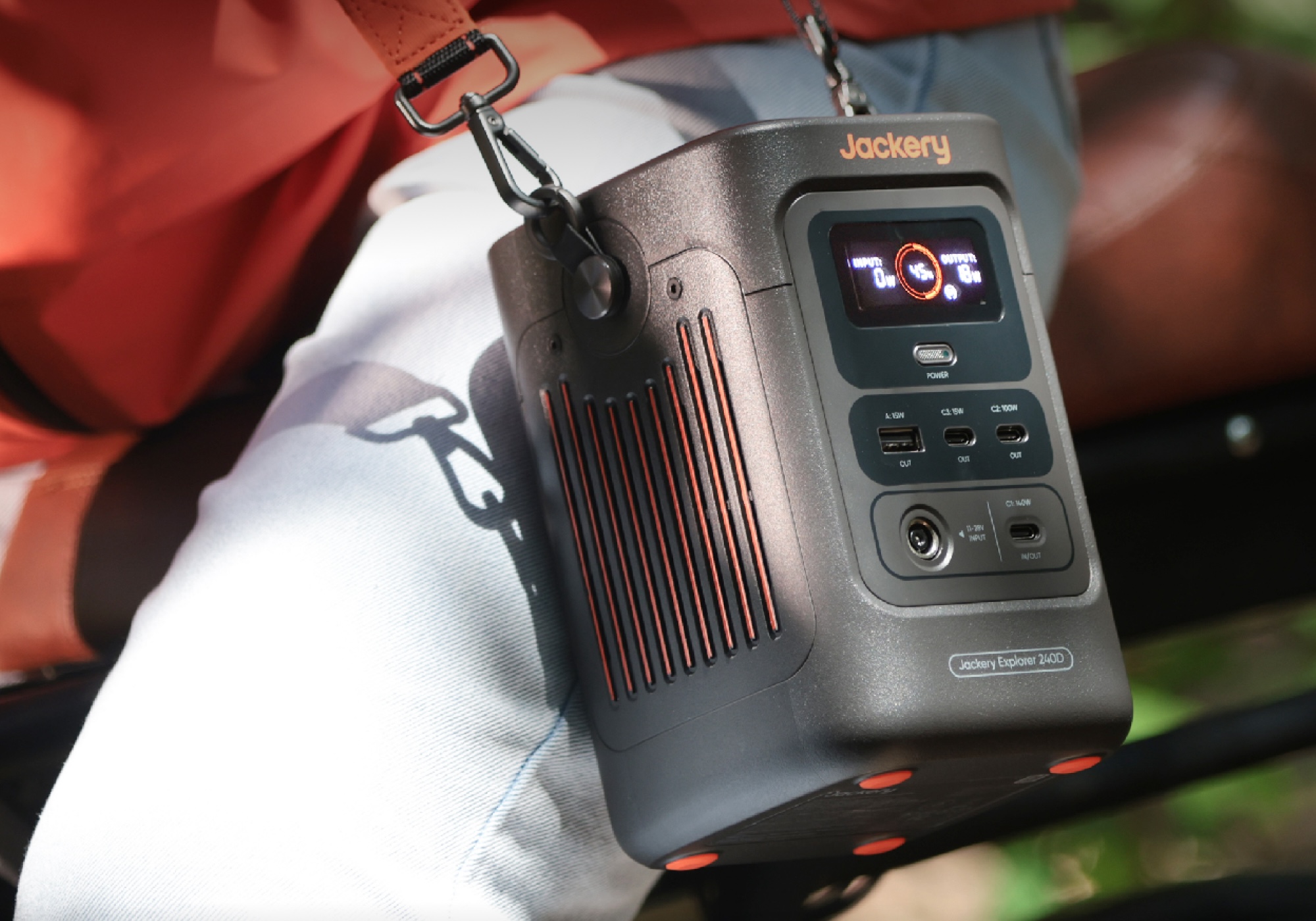 The Jackery Explorer 240D portable power station being carried on someone’s hip.