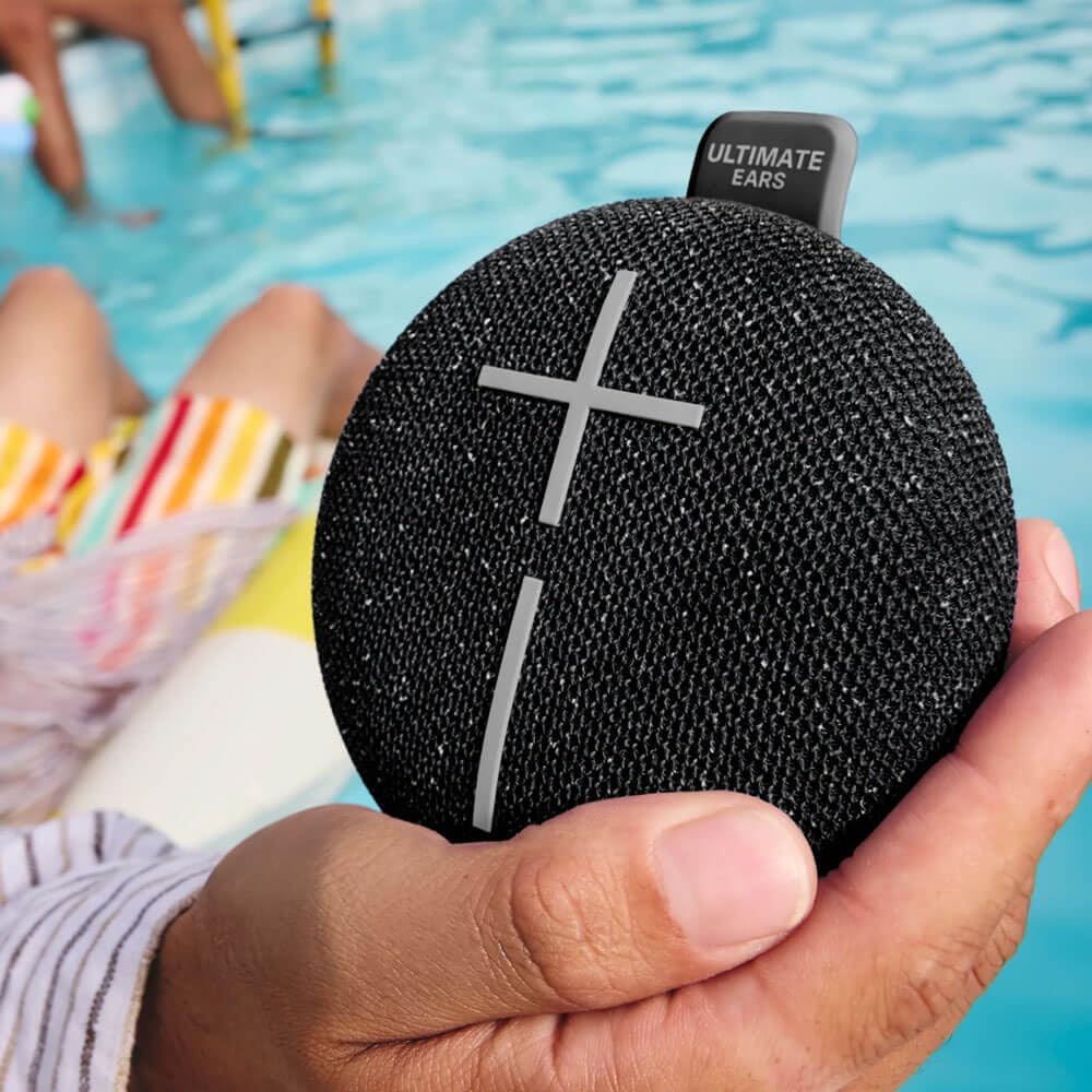 Someone holding the Ultimate Ears Miniroll by the pool.