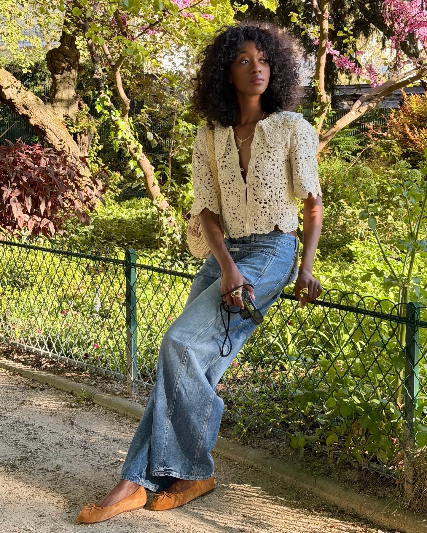 Emmanuelle wearing a crochet top, blue jeans and suede ballet flats.