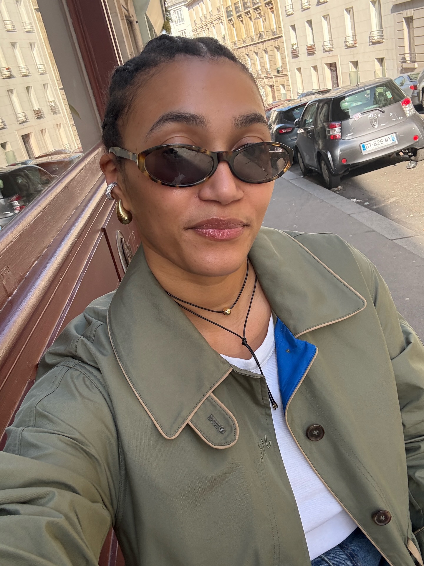L&amp;eacute;na wearing a khaki jacket, white top with statement gold earrings.