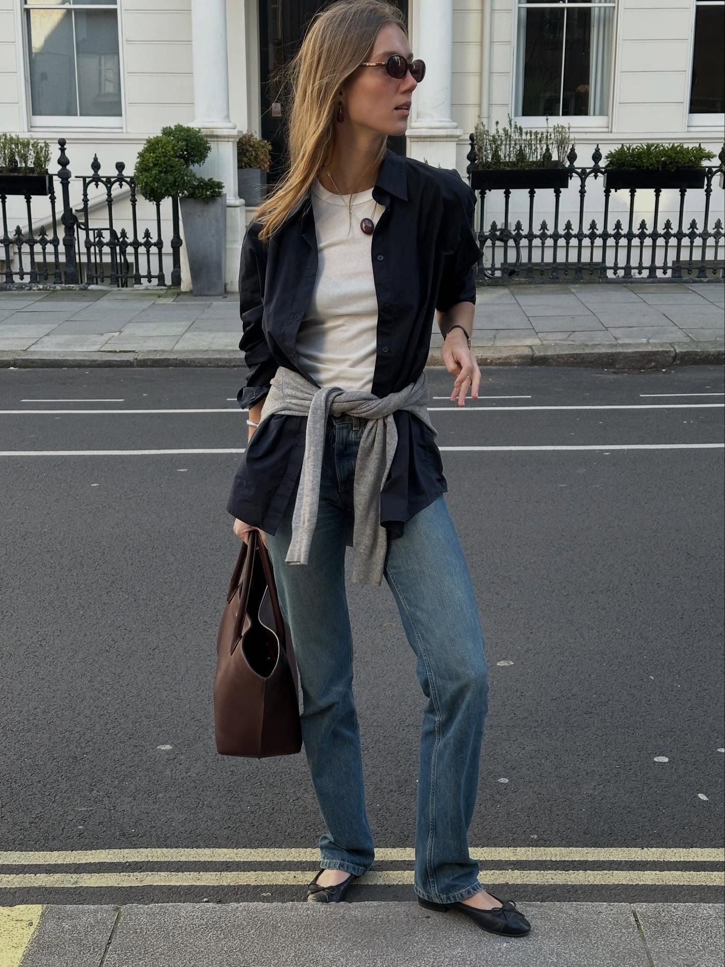 @amaliemoosgaard wearing a white T-shirt and jeans outfit with a blue button-down, ballet flats, and a suede tote