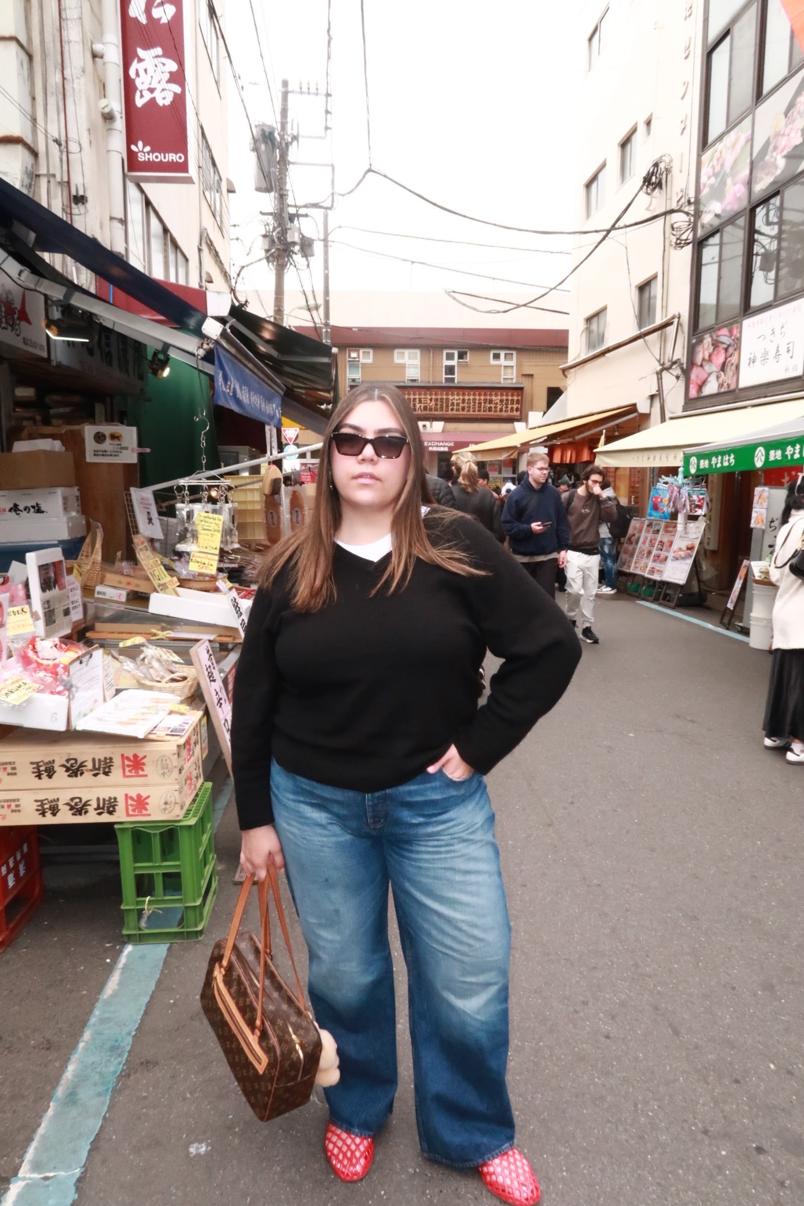 Ana wears a black sweater, jeans, and mesh flats.