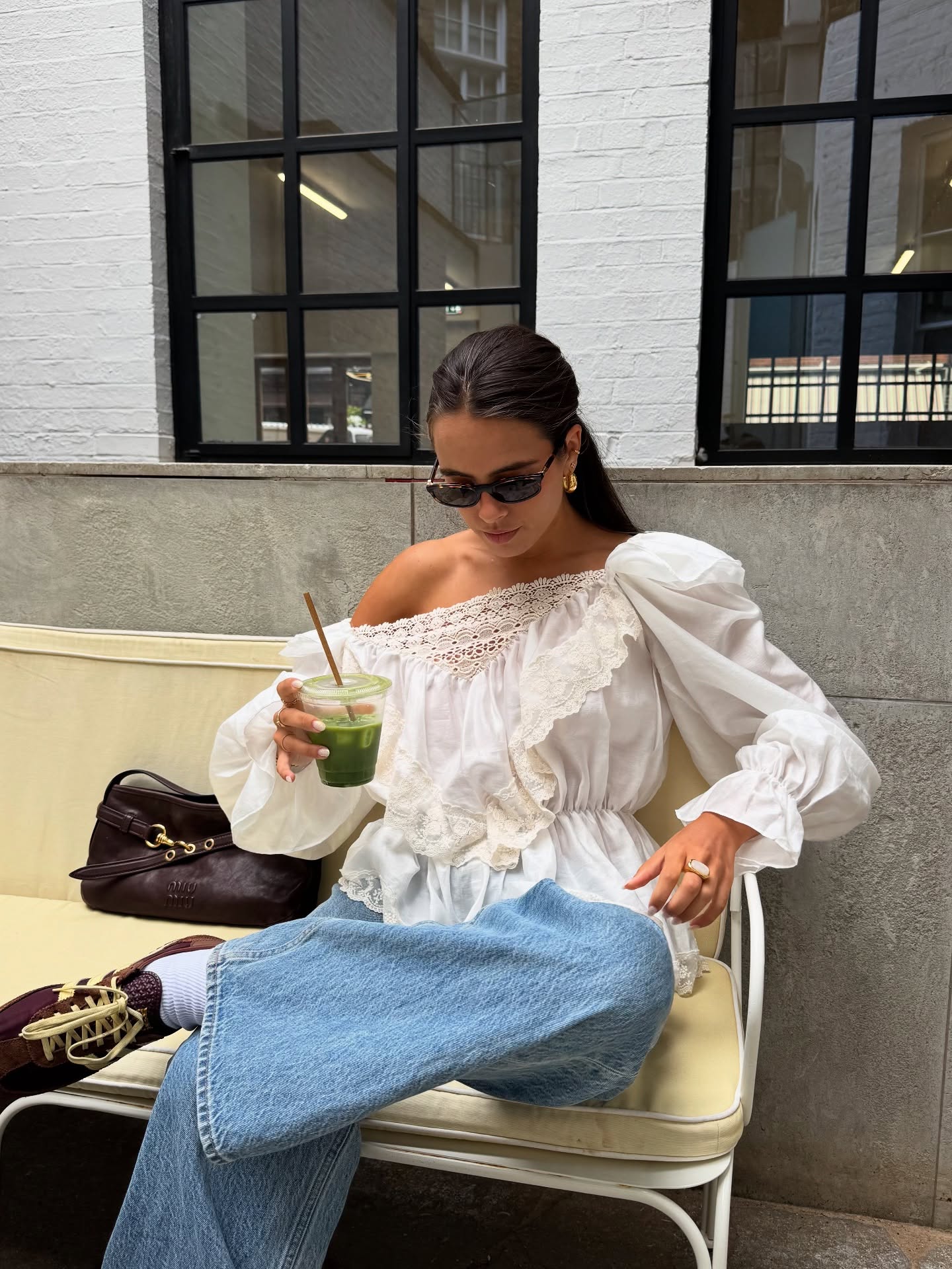 Tia Dewitt wears a white blouse, blue jeans and trainers