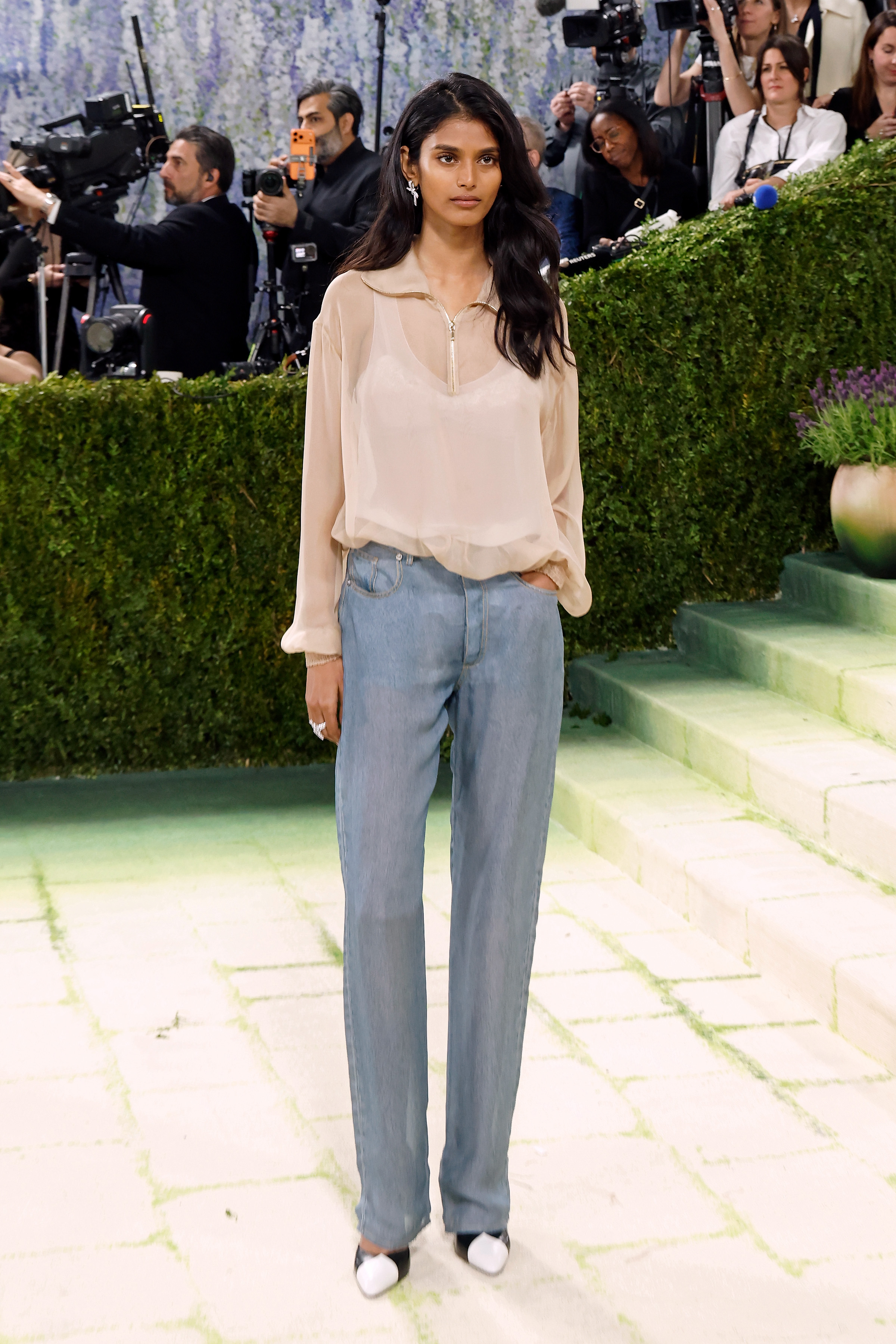 Model Bhavitha Mandava wears straight-leg jeans and a sheer polo top and Chanel two-tone heels on the Met Gala 2026 red carpet.