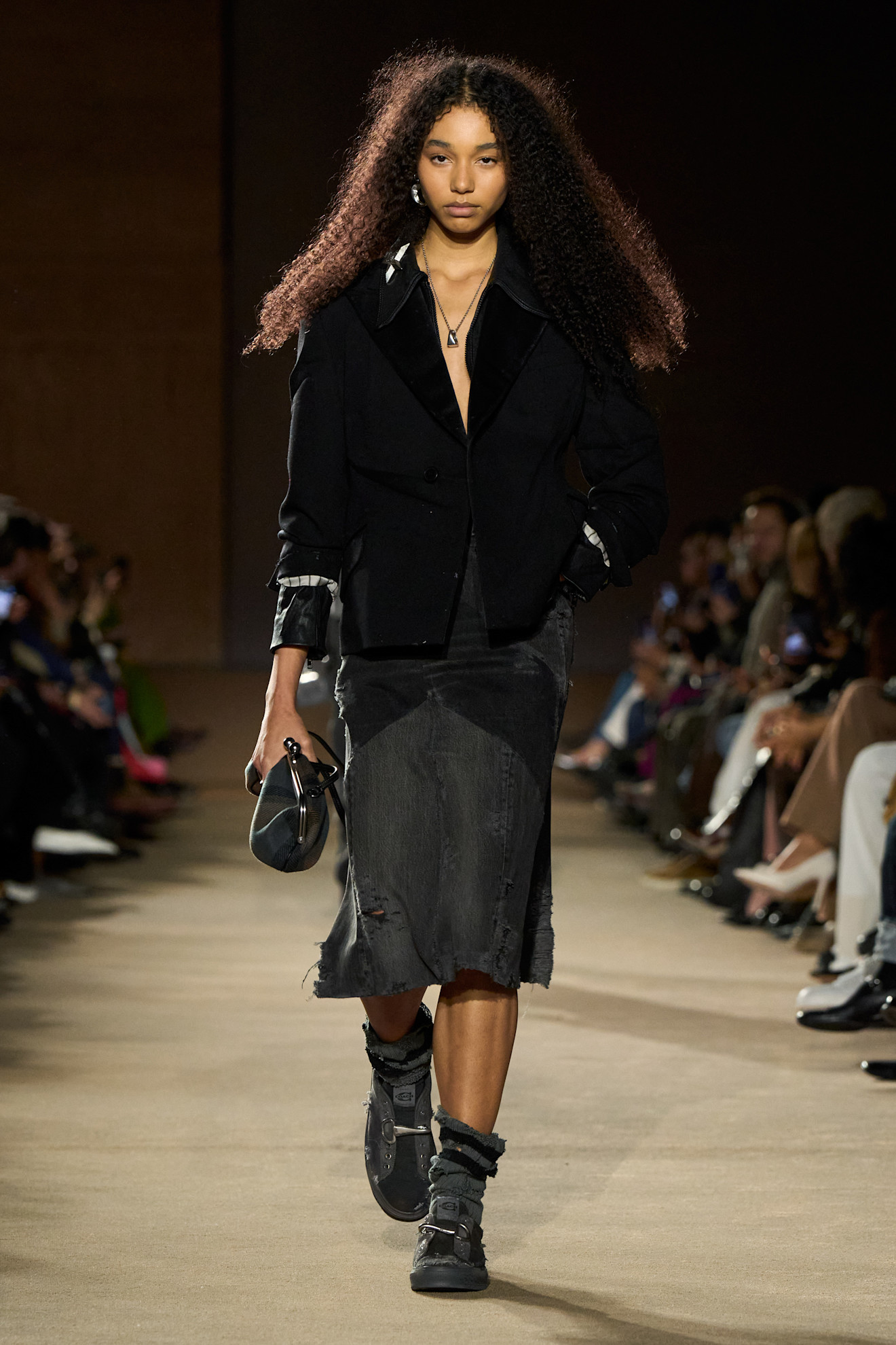 Fall/winter 2026 runway look featuring the everyday clutch handbag trend.