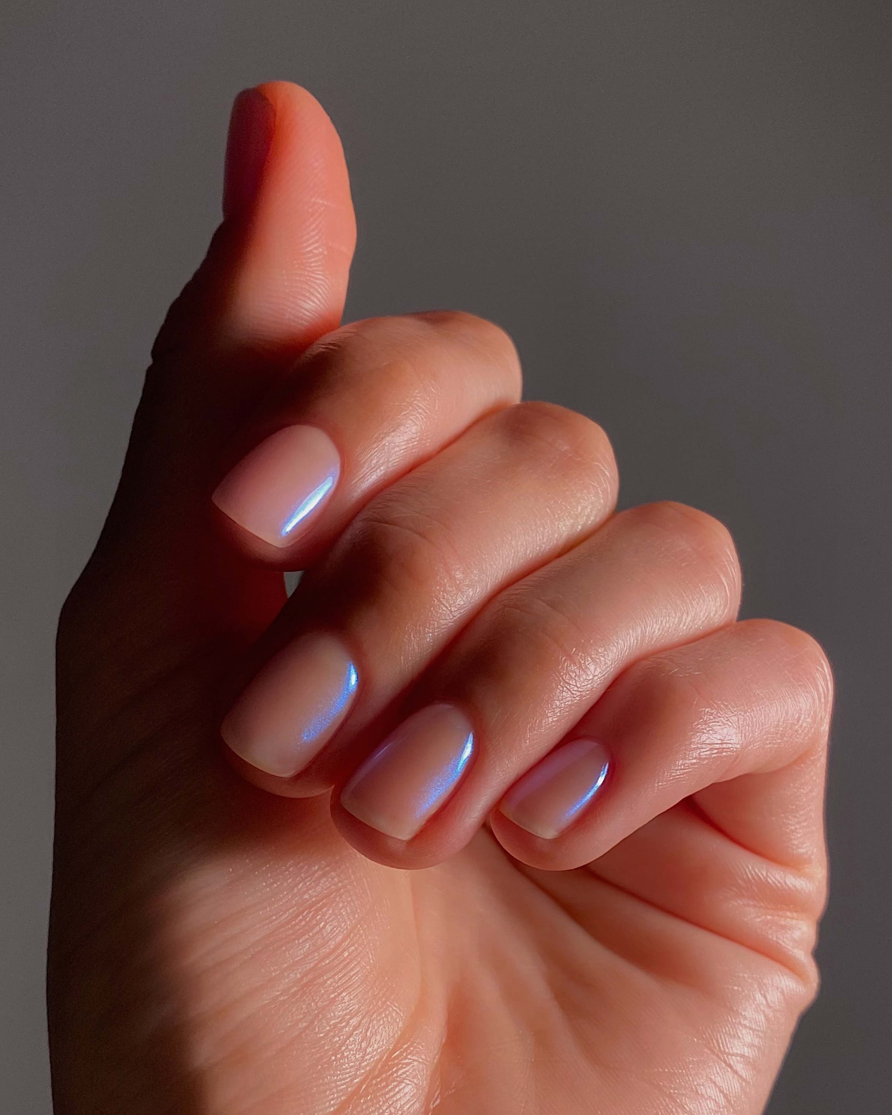 A close up of the blue chrome nails on @matejanova with her nails bent in towards her palm