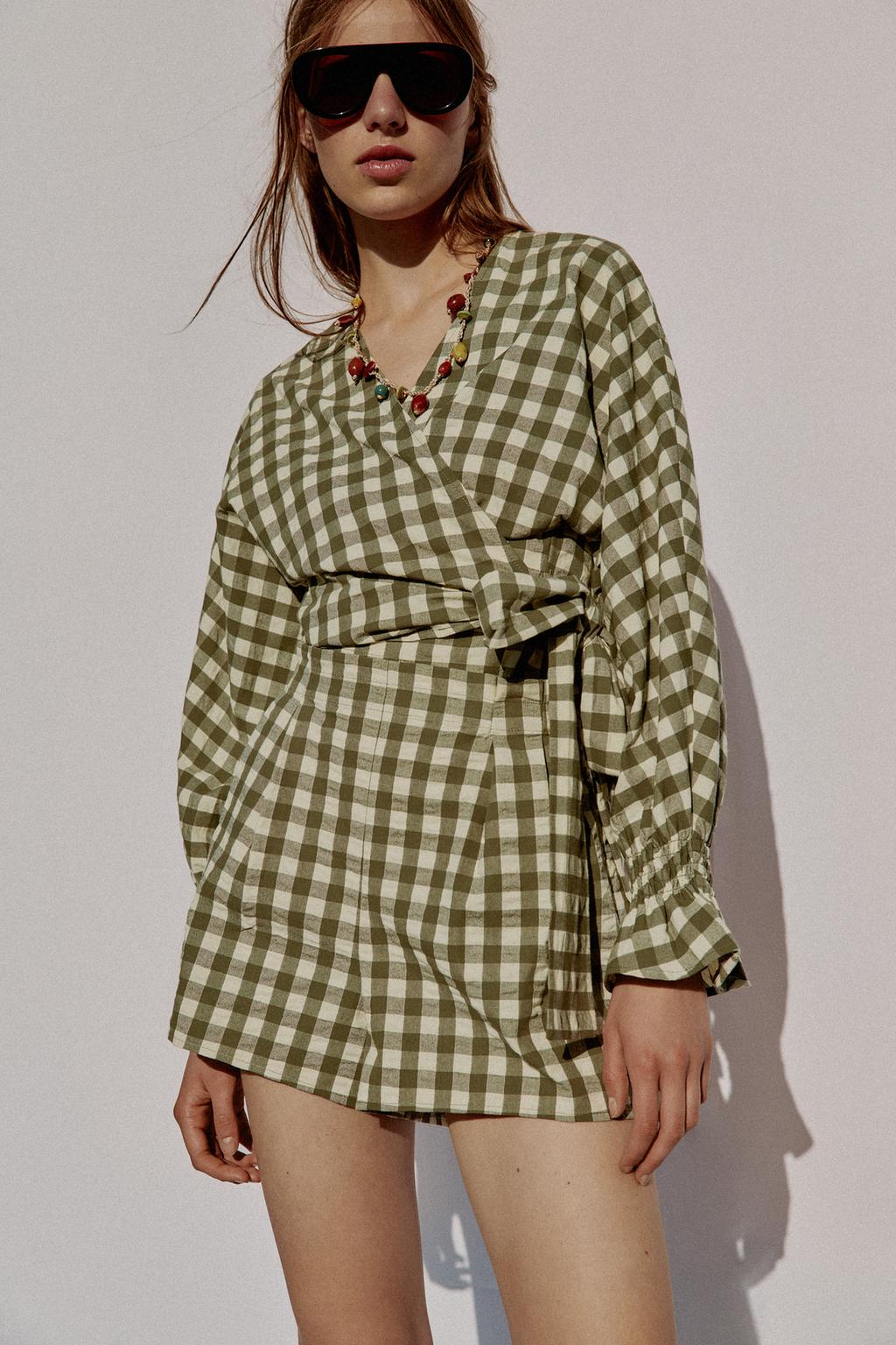 Model wears green gingham matching short set with wrap top.