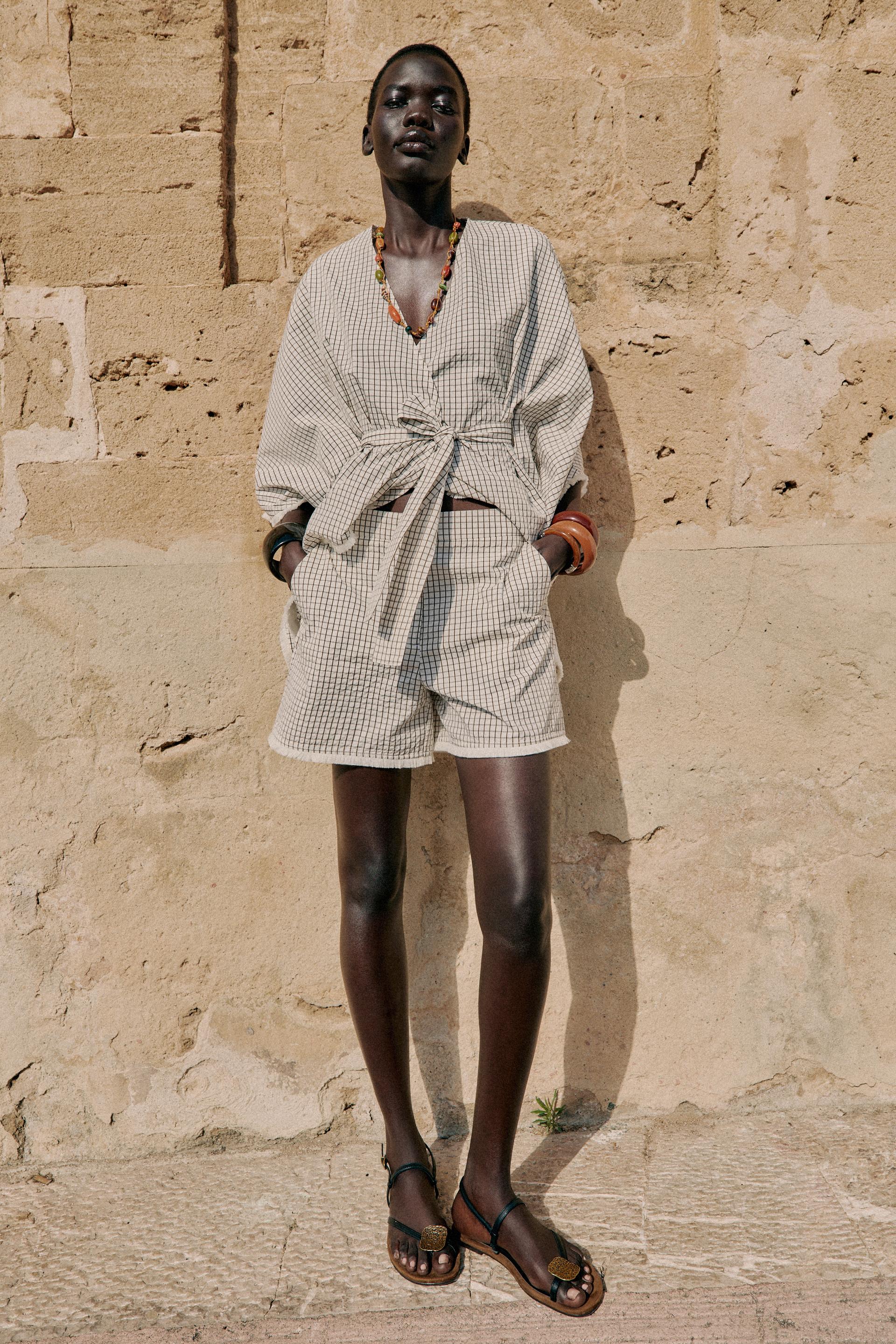 model wears striped short set with sandals.