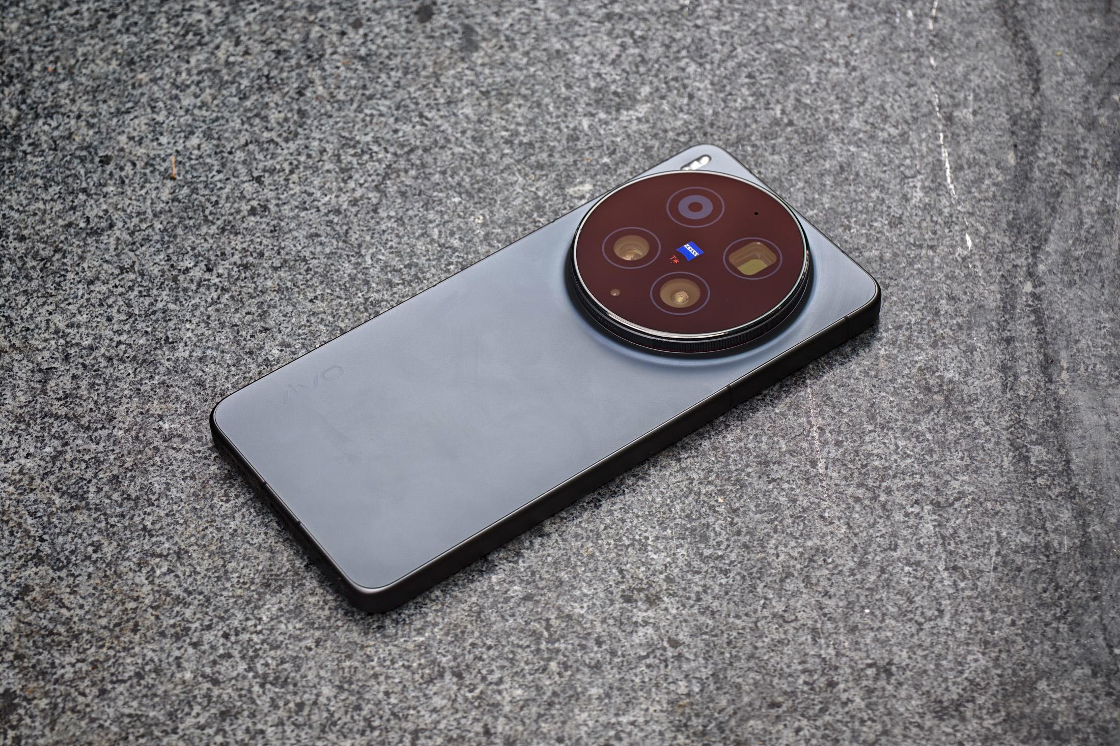 Photo of the Vivo X300 Ultra laying on a gray stone bench.