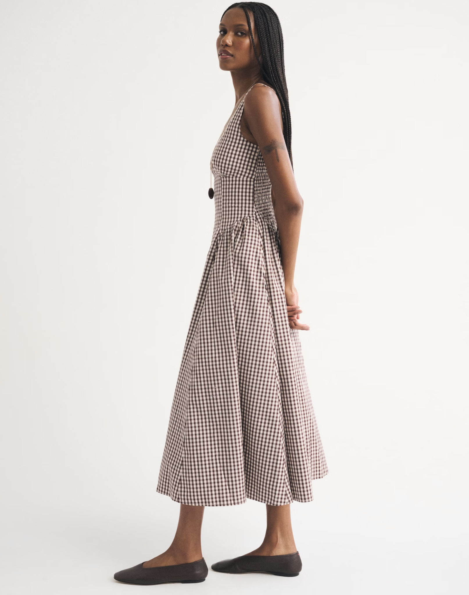girl wearing brown gingham dress