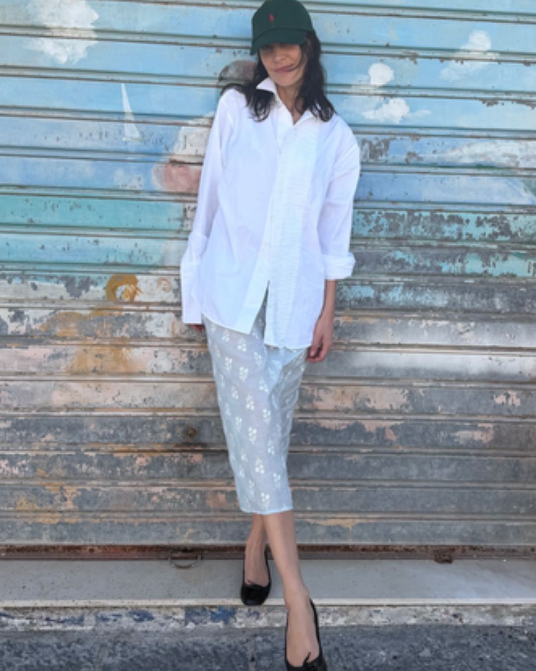 Alexa Chung wears a midiskirt with black ballet flats and a white skirt.