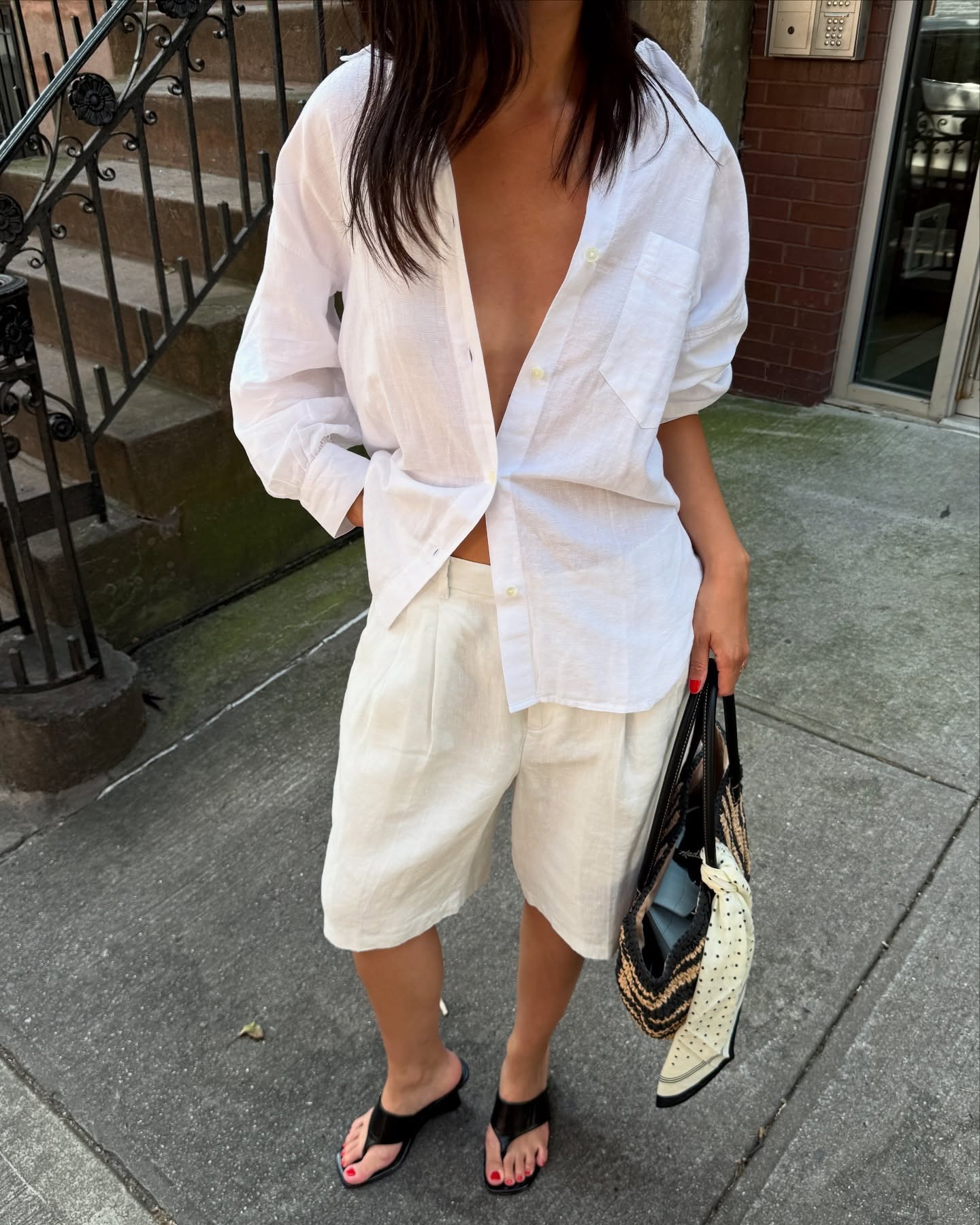 Influencer @mimixn wears sculptural thong heels with a white linen shirt and shorts.
