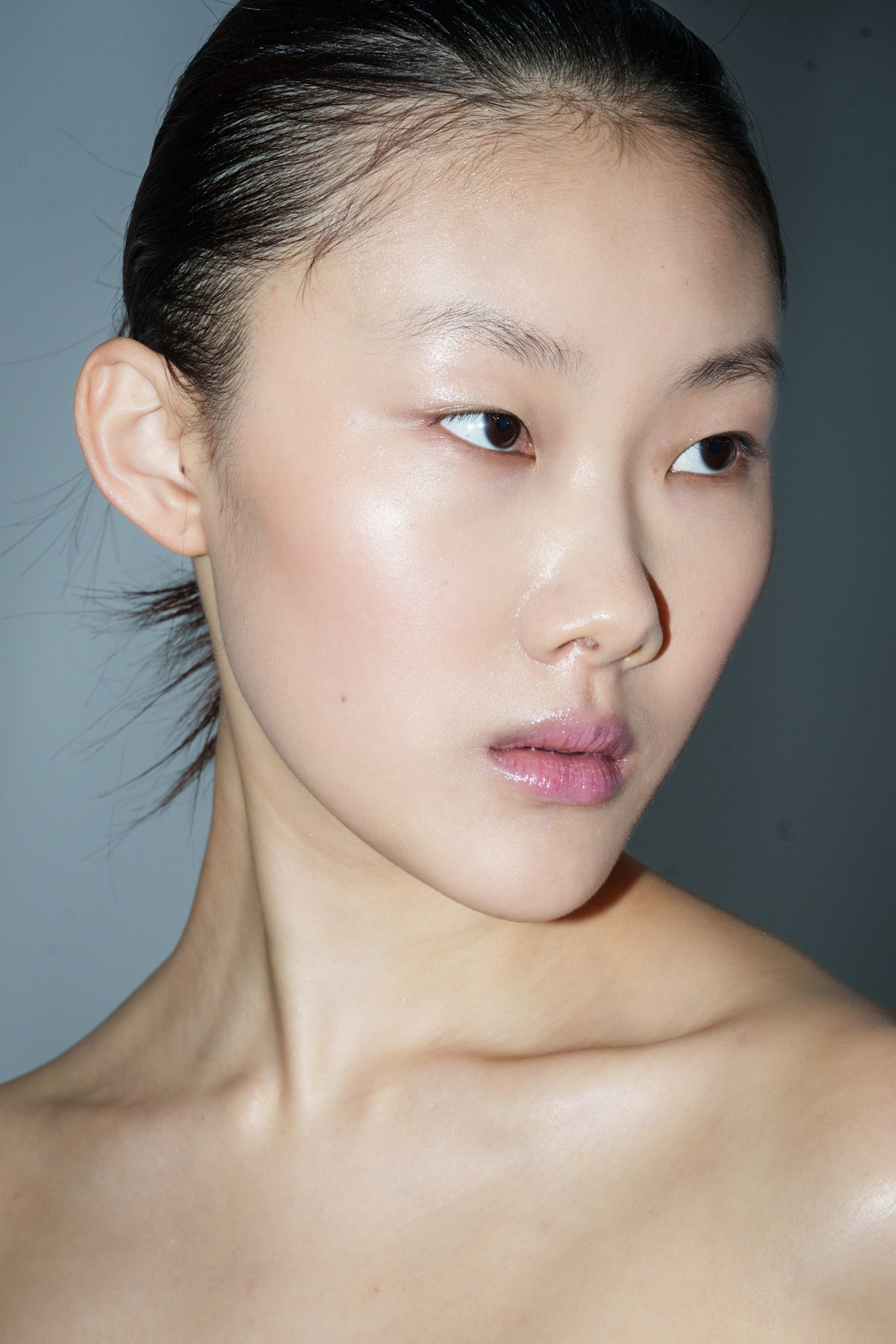A model with glowing skin backstage at Rami Al Ali's S/S 26 show.