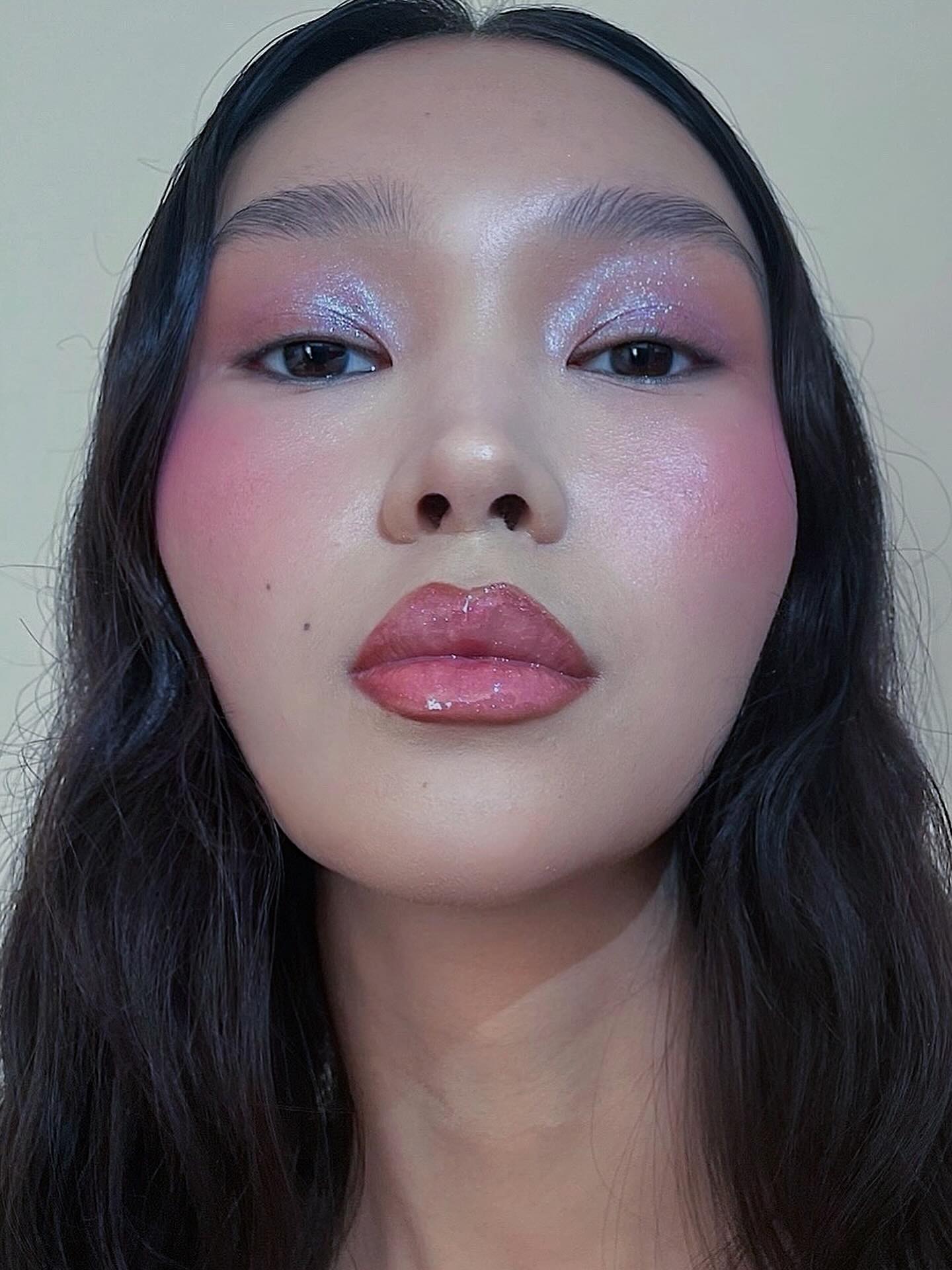 Woman wearing sparkly pink eye shadow and blush.