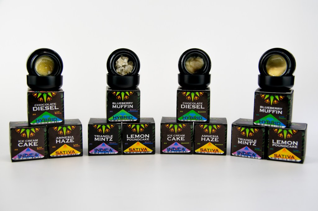Assorted cannabis-infused edible products including chocolate, muffins, ice cream, and more, with various strain and flavor names displayed on the packaging.