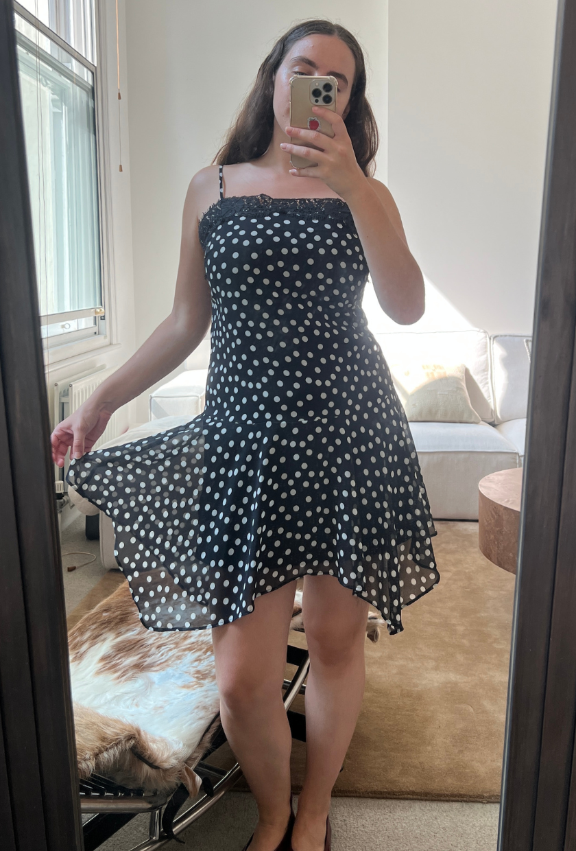 An image of Who What Wear UK fashion writer, Ava Gilchrist, wearing the viral M&amp;amp;S polka-dot lace-trim slip dress. She is a size M and wears it in a size 10.