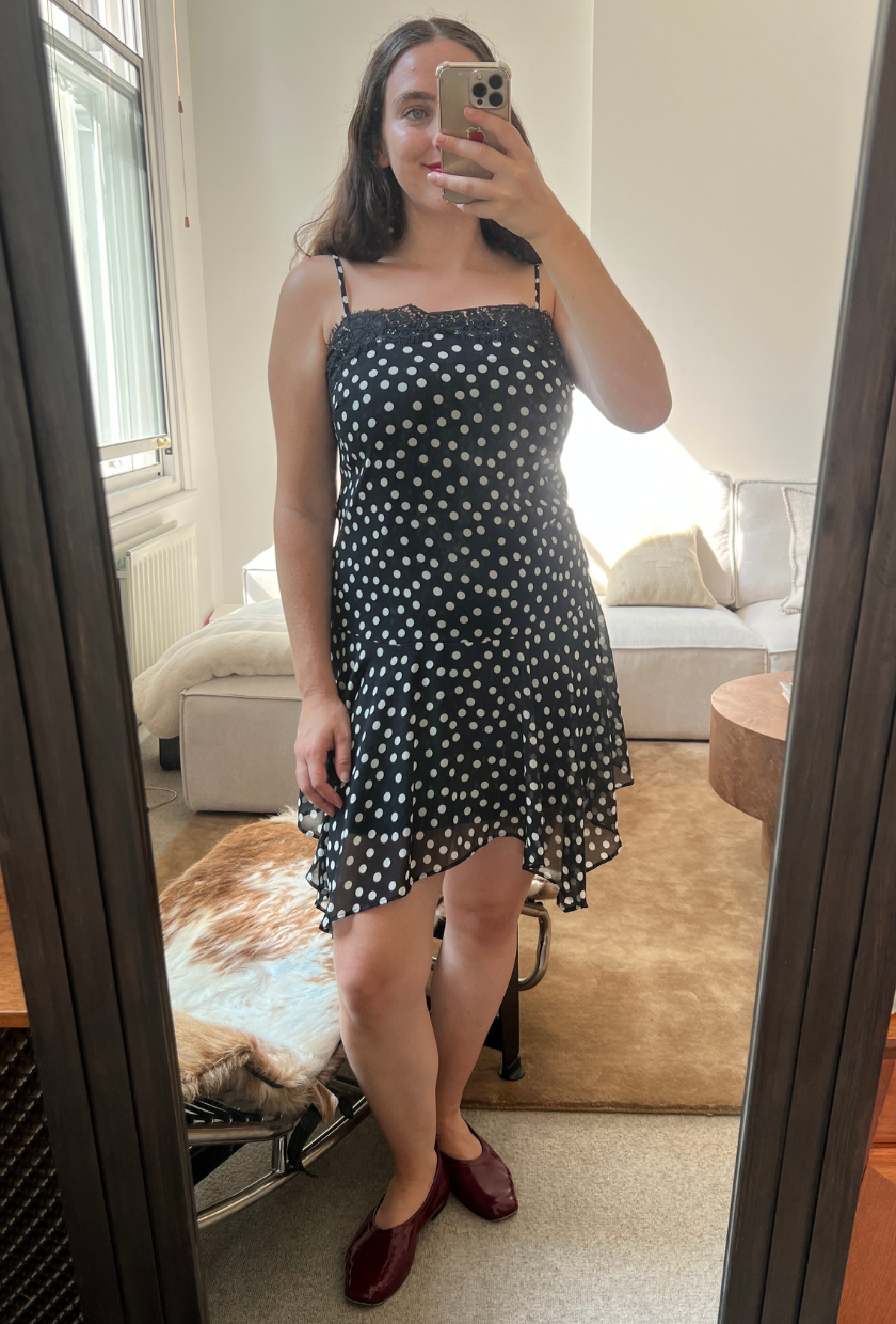 An image of Who What Wear UK fashion writer, Ava Gilchrist, wearing the viral M&amp;amp;S polka-dot lace-trim slip dress. She is a size M and wears it in a size 10.