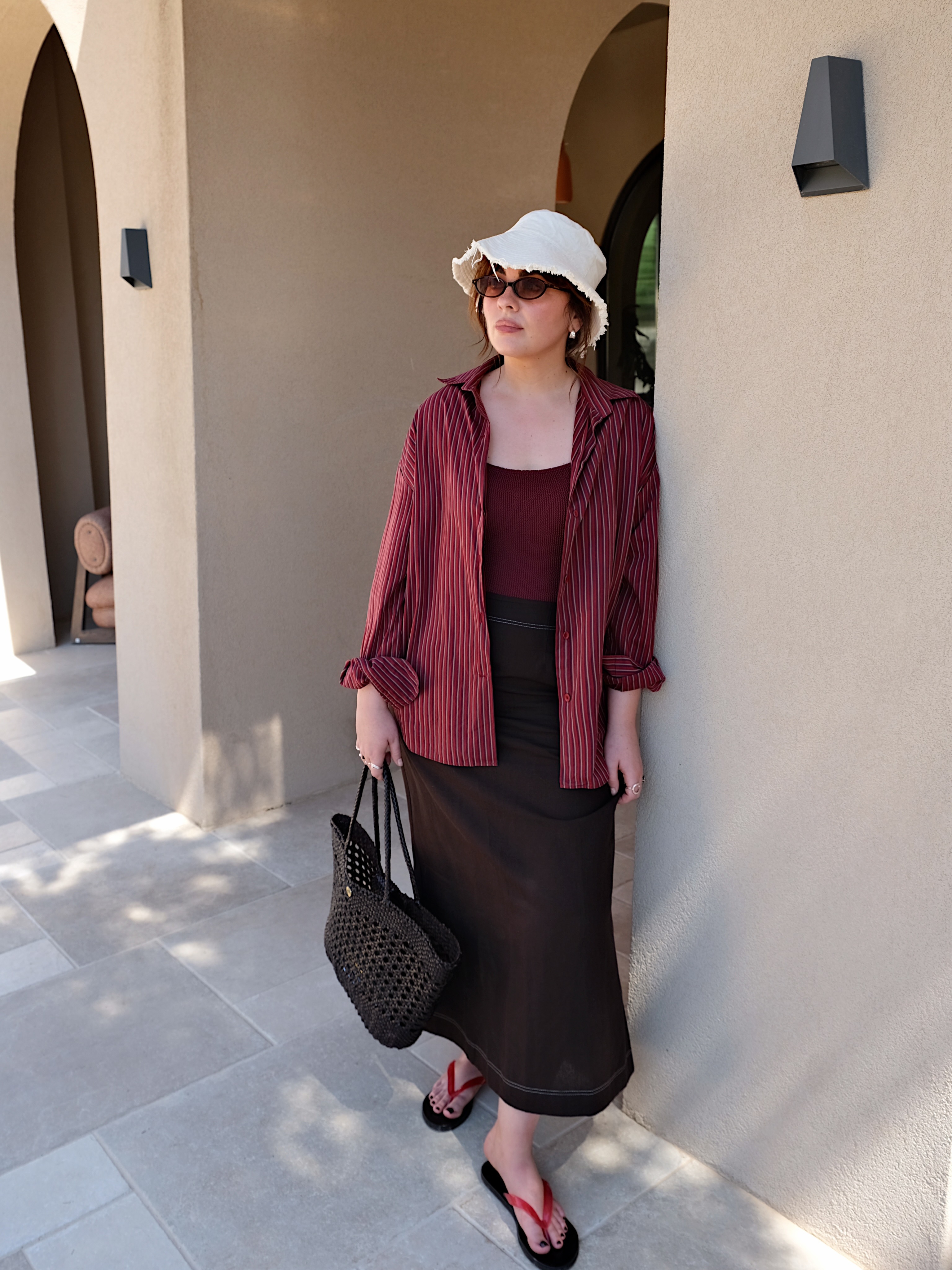 Influencer wearing skirt, linen shirt and red flip-flops