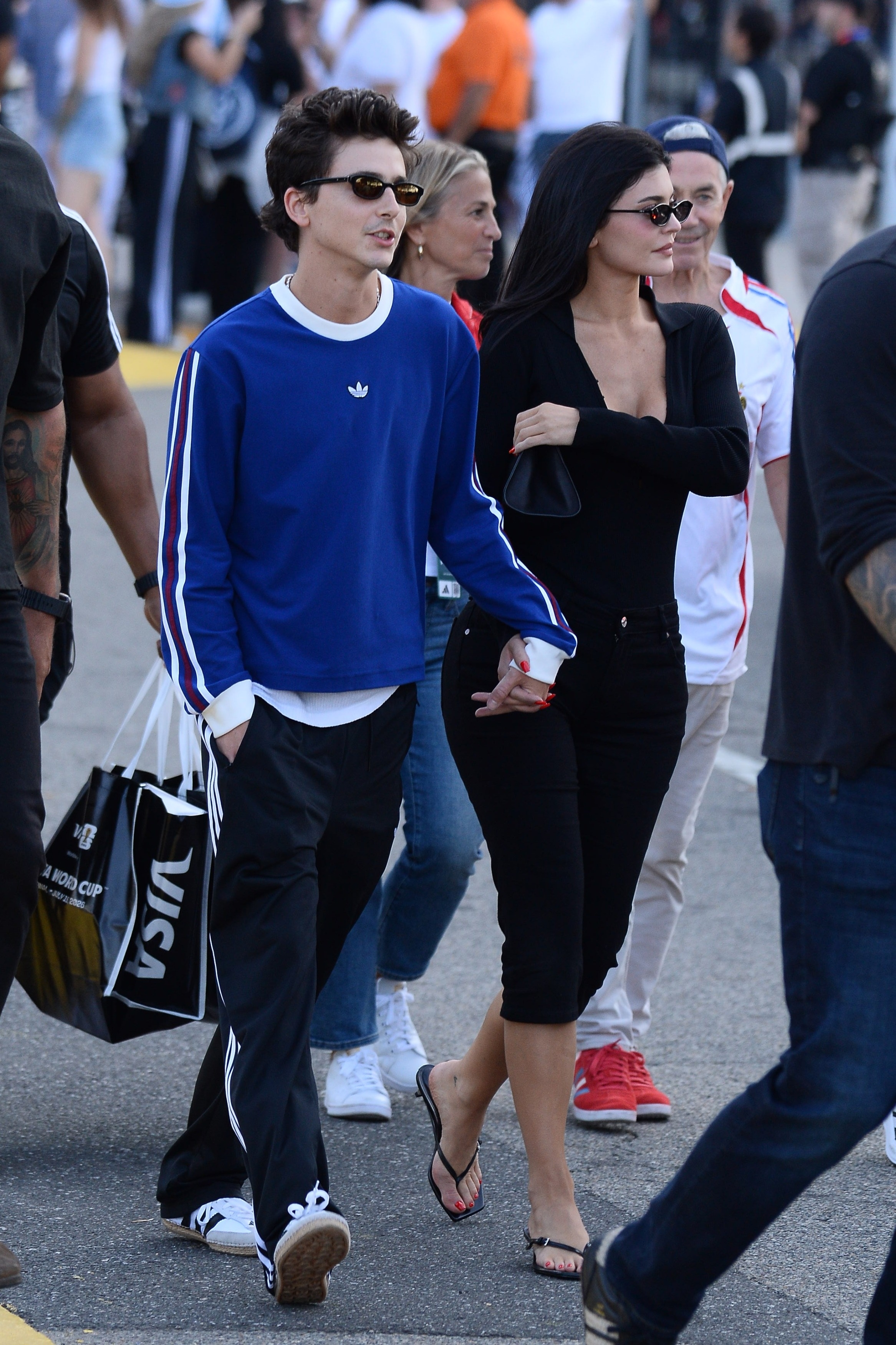 Kylie Jenner exits the World Cup wearing black capri pants with kitten heels and a black cardigan.
