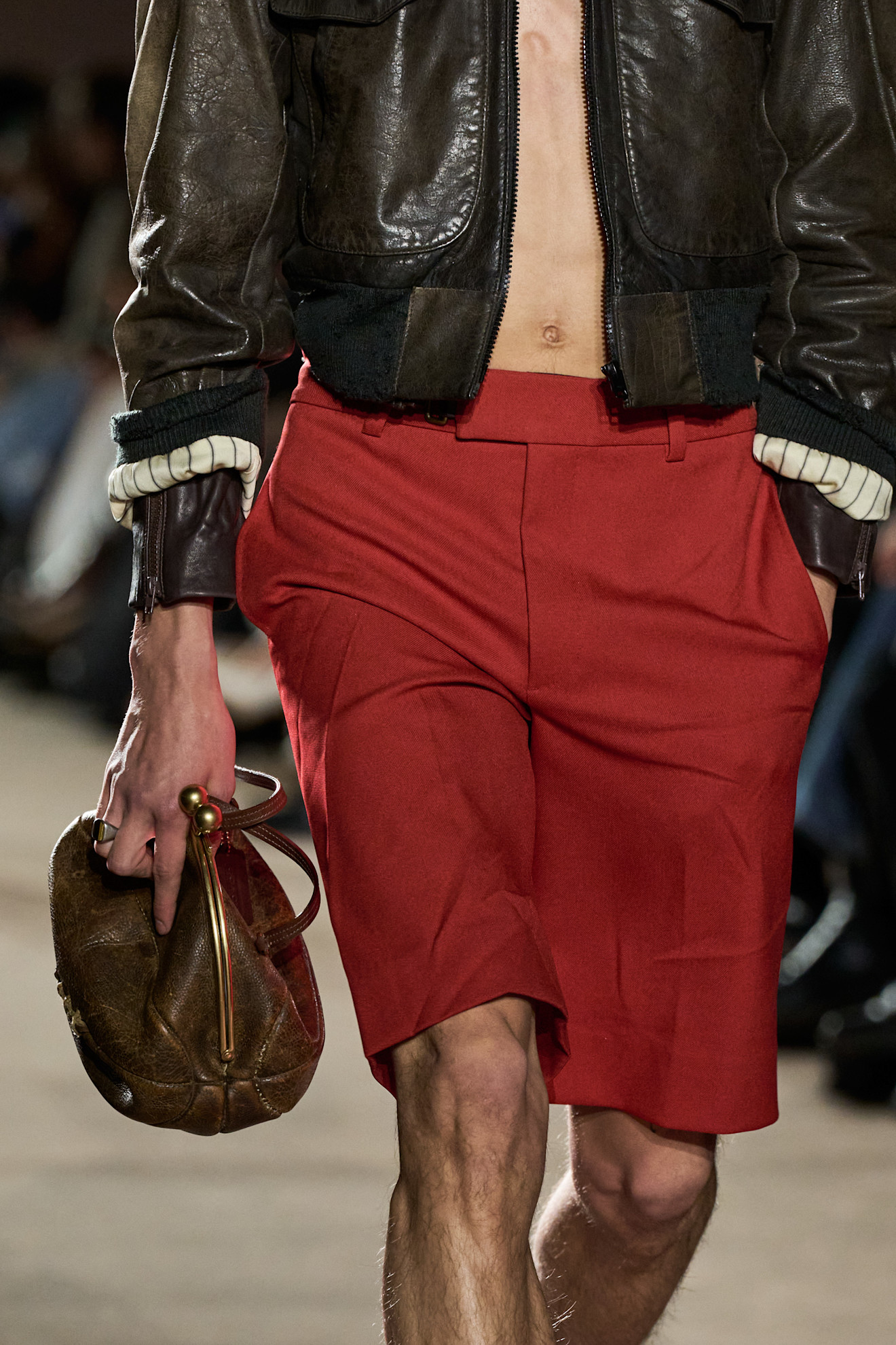 A model carrying a deflated basketball leather Coach clutch bag at the F/W 26 show during New York Fashion Week.