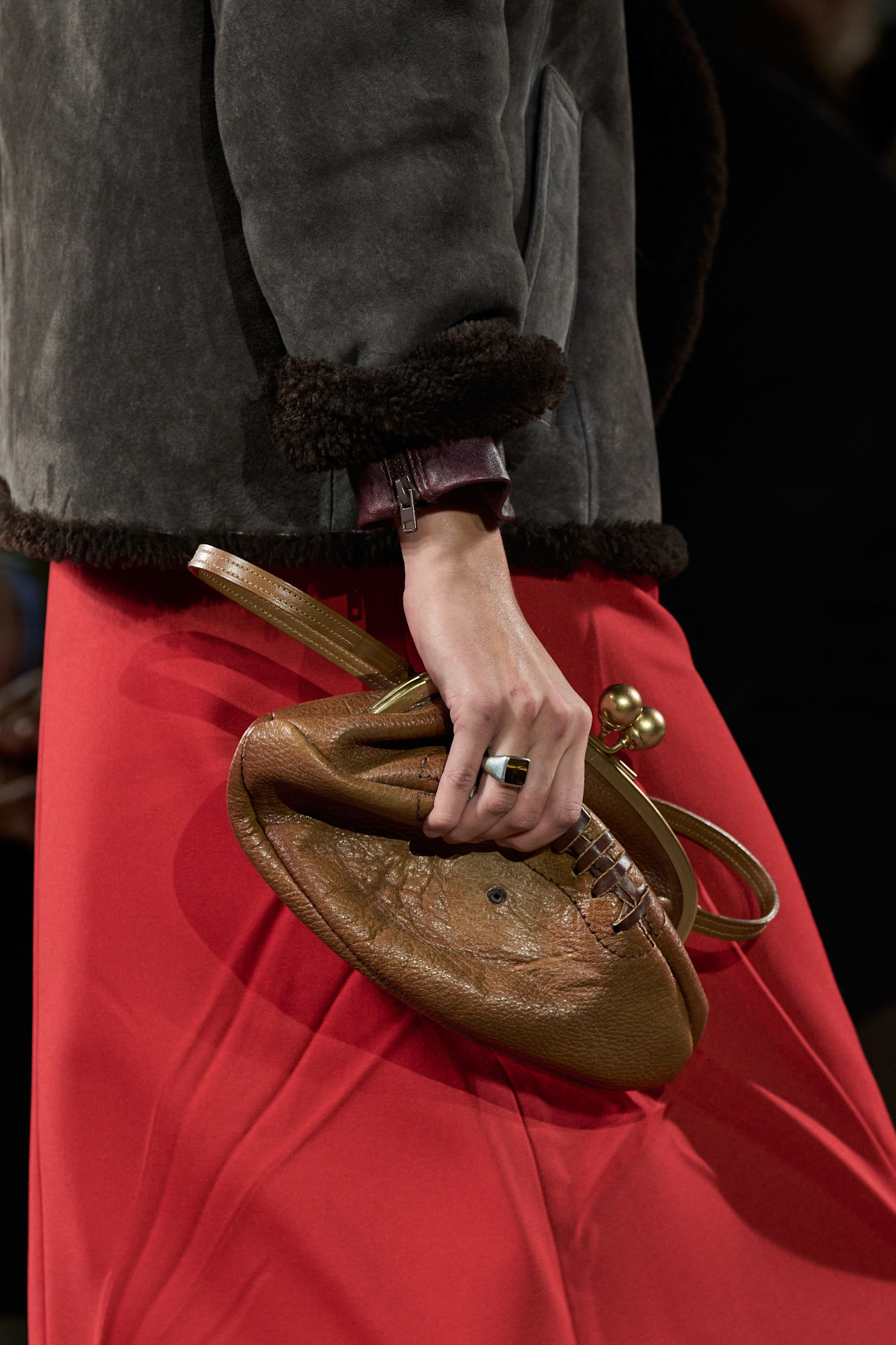 A model carrying a deflated football Coach clutch bag at the F/W 26 show during New York Fashion Week.